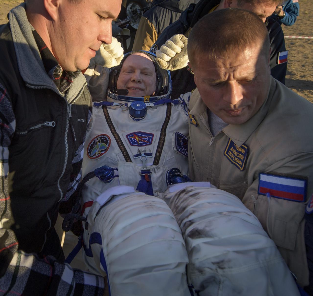 Expedition 56 Flight Engineer and Soyuz Commander Oleg Artemyev of Roscosmos is helped out of the Soyuz MS-08 spacecraft just minutes after he, Expedition 56 Commander Drew Feustel, and Flight Engineer Ricky Arnold of NASA, landed in a remote area near the town of Zhezkazgan, Kazakhstan on Thursday, Oct. 4, 2018. Feustel, Arnold, and Artemyev are returning after 197 days in space where they served as members of the Expedition 55 and 56 crews onboard the International Space Station. Photo Credit: (NASA/Bill Ingalls)