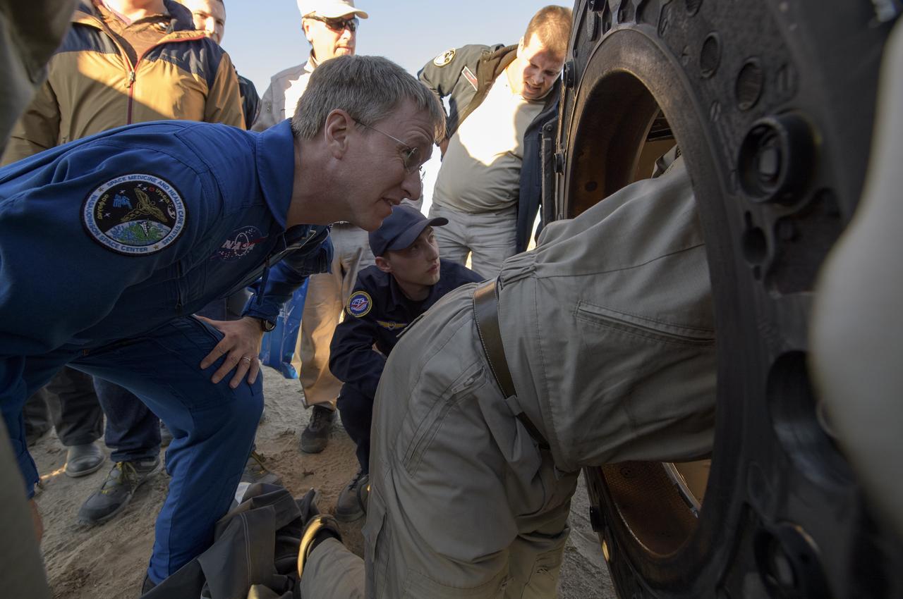 NASA Flight Surgeon Joe Schmid, left, looks inside the Soyuz MS-08 spacecraft to monitor Expedition 56 Commander Drew Feustel and Flight Engineer Ricky Arnold of NASA, along with Flight Engineer and Soyuz Commander Oleg Artemyev of Roscosmos near the town of Zhezkazgan, Kazakhstan on Thursday, Oct. 4, 2018. Feustel, Arnold, and Artemyev are returning after 197 days in space where they served as members of the Expedition 55 and 56 crews onboard the International Space Station. Photo Credit: (NASA/Bill Ingalls)