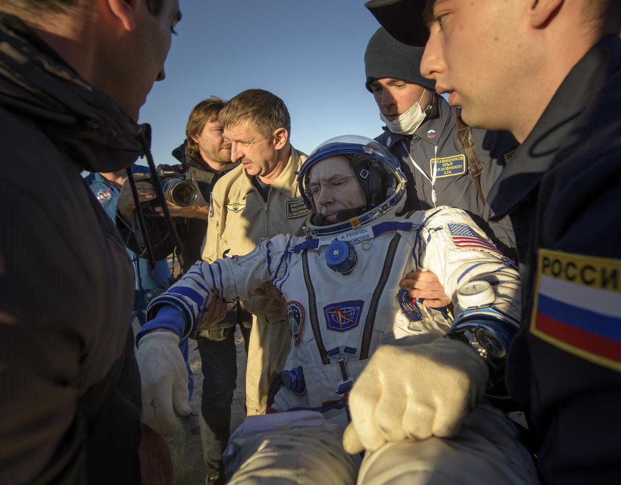 Expedition 56 Commander Drew Feustel of NASA is helped out of the Soyuz MS-08 spacecraft just minutes after he, Expedition 56 Flight Engineer Ricky Arnold of NASA, and Expedition 56 Flight Engineer and Soyuz Commander Oleg Artemyev of Roscosmos, landed in a remote area near the town of Zhezkazgan, Kazakhstan on Thursday, Oct. 4, 2018. Feustel, Arnold, and Artemyev are returning after 197 days in space where they served as members of the Expedition 55 and 56 crews onboard the International Space Station. Photo Credit: (NASA/Bill Ingalls)