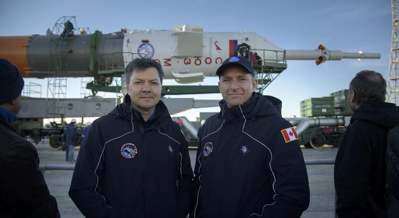Expedition 57 backup crewmember Oleg Kononenko of Roscosmos, left, and David Saint-Jacques of the Canadian Space Agency pose for a photograph by the Soyuz TM-10 spacecraft after it rolled out to the launch pad, Tuesday, Oct. 9, 2018 at the Baikonur Cosmodrome in Kazakhstan. Expedition 57 crewmembers Nick Hague of NASA and Alexey Ovchinin of Roscosmos are scheduled to launch on October 11 and will spend the next six months living and working aboard the International Space Station. Photo Credit: (NASA/Bill Ingalls)