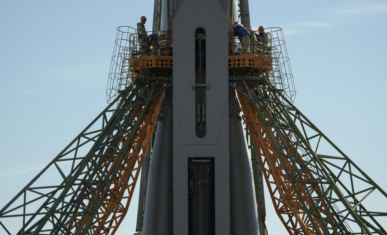 Workers are seen around the Soyuz rocket after it  was raised into a vertical position on the launch pad, Tuesday, Oct. 9, 2018 at the Baikonur Cosmodrome in Kazakhstan. Expedition 57 crewmembers Nick Hague of NASA and Alexey Ovchinin of Roscosmos are scheduled to launch on October 11 and will spend the next six months living and working aboard the International Space Station. Photo Credit: (NASA/Bill Ingalls)