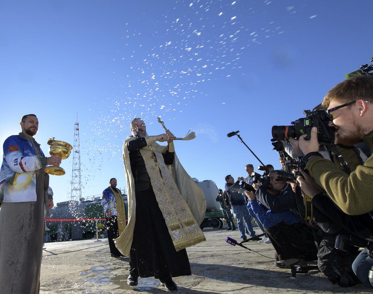 Russian Orthodox Priest, Father Sergei, blesses members of the media after having blessed the Soyuz rocket at the Baikonur Cosmodrome launch pad, Wednesday, Oct. 10, 2018 in Baikonur, Kazakhstan. Expedition 57 crewmembers Nick Hague of NASA and Alexey Ovchinin of Roscosmos are scheduled to launch on October 11 and will spend the next six months living and working aboard the International Space Station. Photo Credit: (NASA/Bill Ingalls)