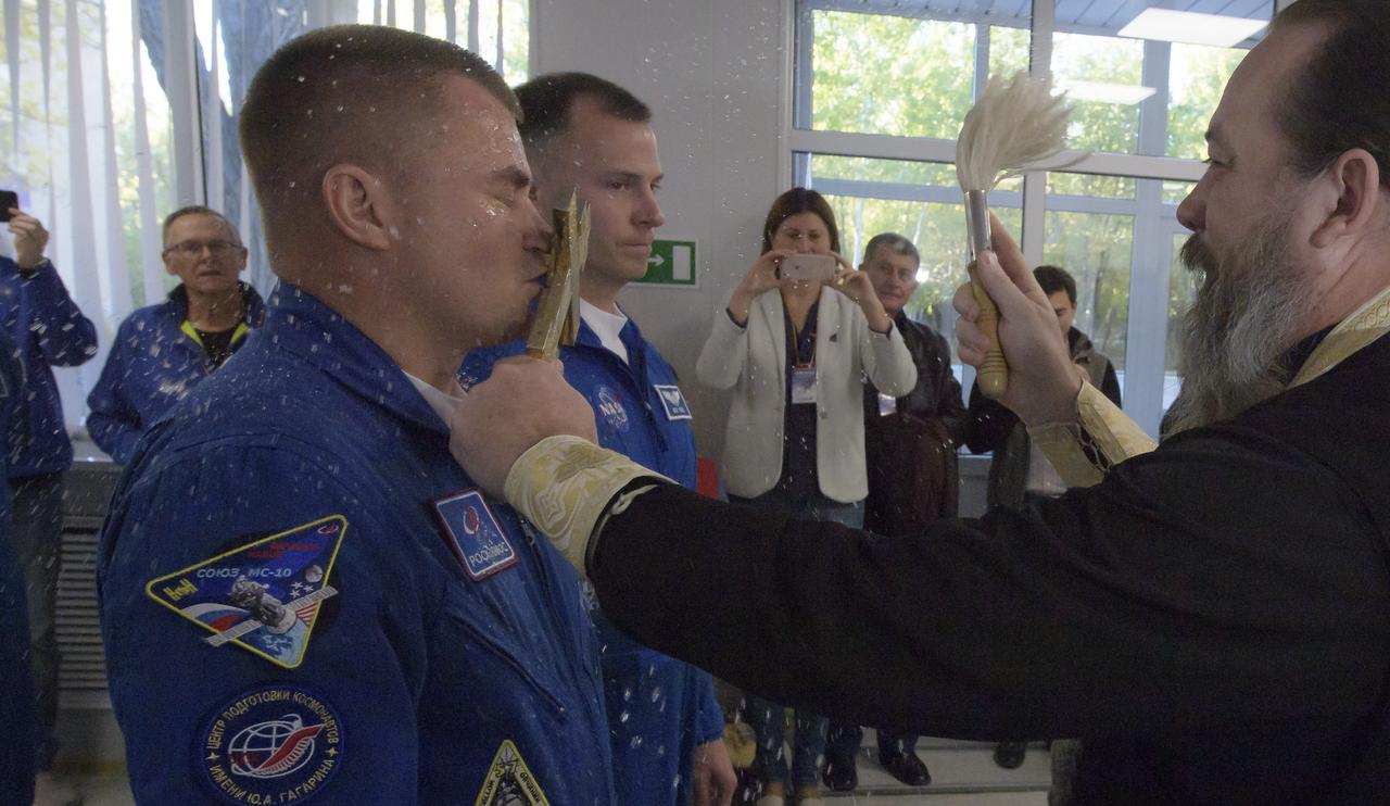 Expedition 57 Flight Engineer Alexey Ovchinin of Roscosmos, left, is blessed by a Russian Orthodox Priest in the Cosmonaut Hotel prior to departing for launch on a Soyuz rocket with Flight Engineer Nick Hague of NASA, Thursday, Oct. 11, 2018 in Baikonur, Kazakhstan. During the Soyuz spacecraft's climb to orbit, an anomaly occurred, resulting in an abort downrange. The crew was quickly recovered and is in good condition. Photo Credit: (NASA/Bill Ingalls)