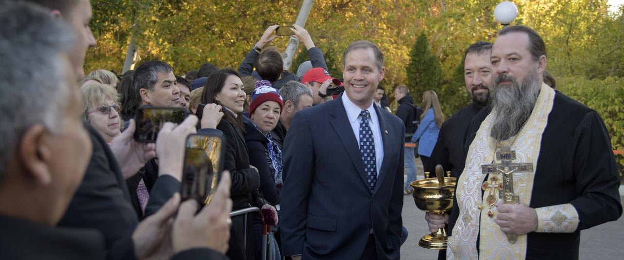 NASA Administrator Jim Bridenstine poses for a photograph with Russian Orthodox Priest, Father Sergei, as they await the Cosmonaut Hotel departure of Expedition 57 Flight Engineer Alexey Ovchinin of Roscosmos, and Flight Engineer Nick Hague of NASA to building 254 to suit-up for their Soyuz launch, Thursday, Oct. 11, 2018 in Baikonur, Kazakhstan. During the Soyuz spacecraft's climb to orbit, an anomaly occurred, resulting in an abort downrange. The crew was quickly recovered and is in good condition. Photo Credit: (NASA/Bill Ingalls)