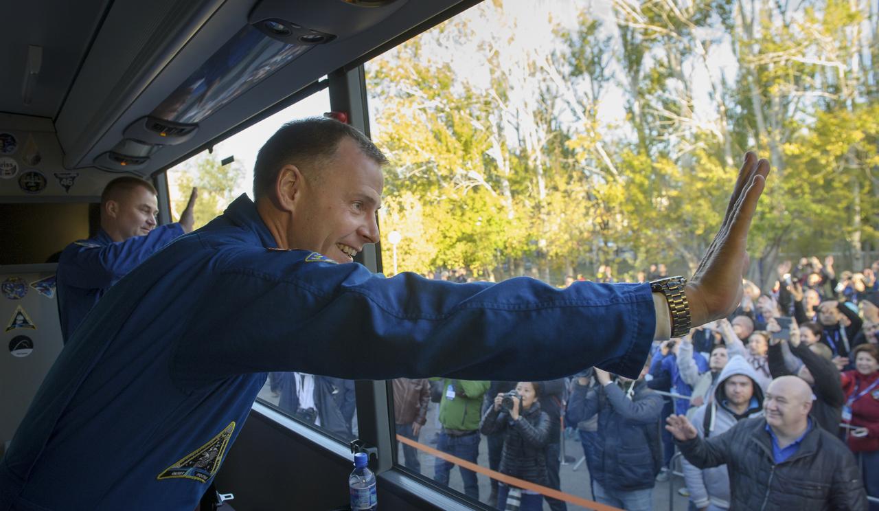 Expedition 57 Flight Engineer Alexey Ovchinin of Roscosmos, left, and Flight Engineer Nick Hague of NASA wave farewell from a bus outside the Cosmonaut Hotel prior to departing for launch on a Soyuz rocket, Thursday, Oct. 11, 2018 in Baikonur, Kazakhstan. During the Soyuz spacecraft's climb to orbit, an anomaly occurred, resulting in an abort downrange. The crew was quickly recovered and is in good condition. Photo Credit: (NASA/GCTC/Irina Spector)