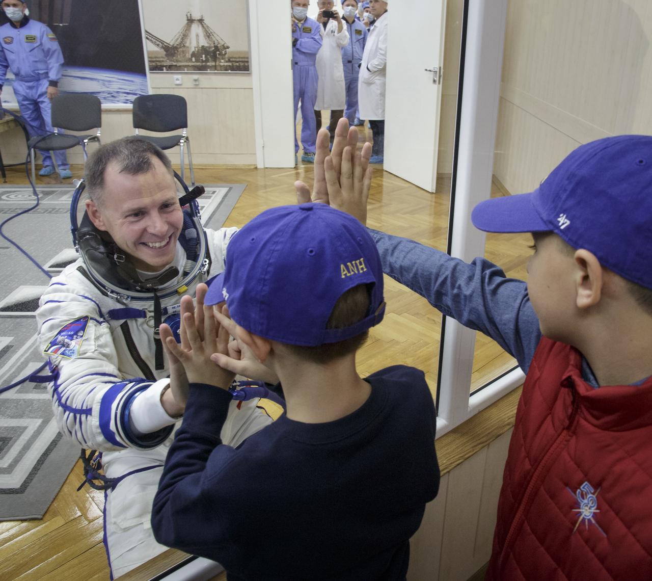 Expedition 57 Flight Engineer Nick Hague of NASA says farewell to his sons after having his Sokol suit pressure checked ahead of his launch on a Soyuz rocket with Expedition 57 Flight Engineer Alexey Ovchinin of Roscosmos, Thursday, Oct. 11, 2018 at the Baikonur Cosmodrome in Kazakhstan. During the Soyuz spacecraft's climb to orbit, an anomaly occurred, resulting in an abort downrange. The crew was quickly recovered and is in good condition. Photo Credit: (NASA/Victor Zelentsov)