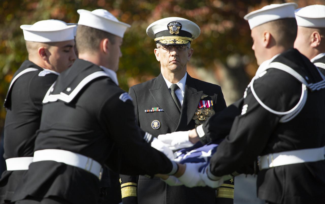 U.S. Navy Rear Adm. James Bynum looks on as a U.S. Navy Honor Guard folds the American Flag during interment services for former astronaut Alan Bean, Thursday, Nov. 8, 2018 at Arlington National Cemetery in Virginia. Selected as an astronaut in 1963, Bean flew in space twice, becoming the fourth human to walk on the Moon on Nov. 19, 1969 and spent 59 days in space as commander of the second Skylab mission in 1973. Photo Credit: (NASA/Joel Kowsky)