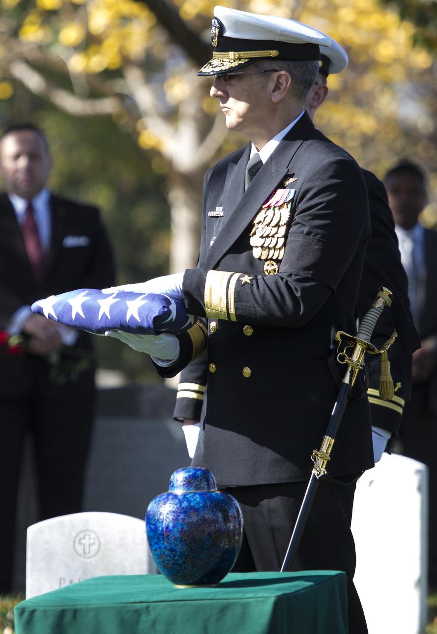 U.S. Navy Rear Adm. James Bynum prepares to present the folded American Flag to Leslie Bean, wife of former astronaut Alan Bean, during his interment service, Thursday, Nov. 8, 2018 at Arlington National Cemetery in Virginia. Selected as an astronaut in 1963, Bean flew in space twice, becoming the fourth human to walk on the Moon on Nov. 19, 1969 and spent 59 days in space as commander of the second Skylab mission in 1973. Photo Credit: (NASA/Joel Kowsky)
