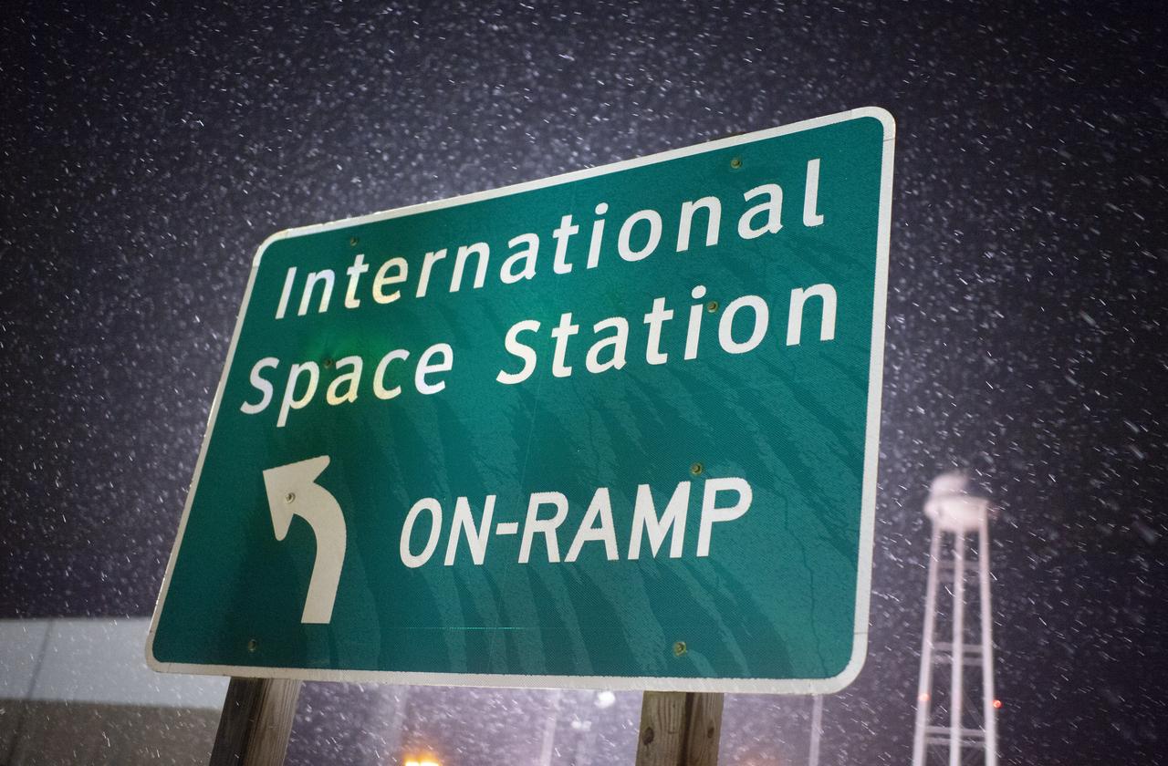A sign at the entrance to Pad-0A is seen as the Northrop Grumman Antares rocket is rolled from the Horizontal Integration Facility (HIF) to Pad-0A, Monday, Nov. 12, 2018 at NASA's Wallops Flight Facility in Virginia. Northrop Grumman's 10th contracted cargo resupply mission for NASA to the International Space Station will deliver about 7,500 pounds of science and research, crew supplies and vehicle hardware to the orbital laboratory and its crew. Launch is scheduled for Nov. 15 at 4:49 a.m. EST. Photo Credit: (NASA/Joel Kowsky)