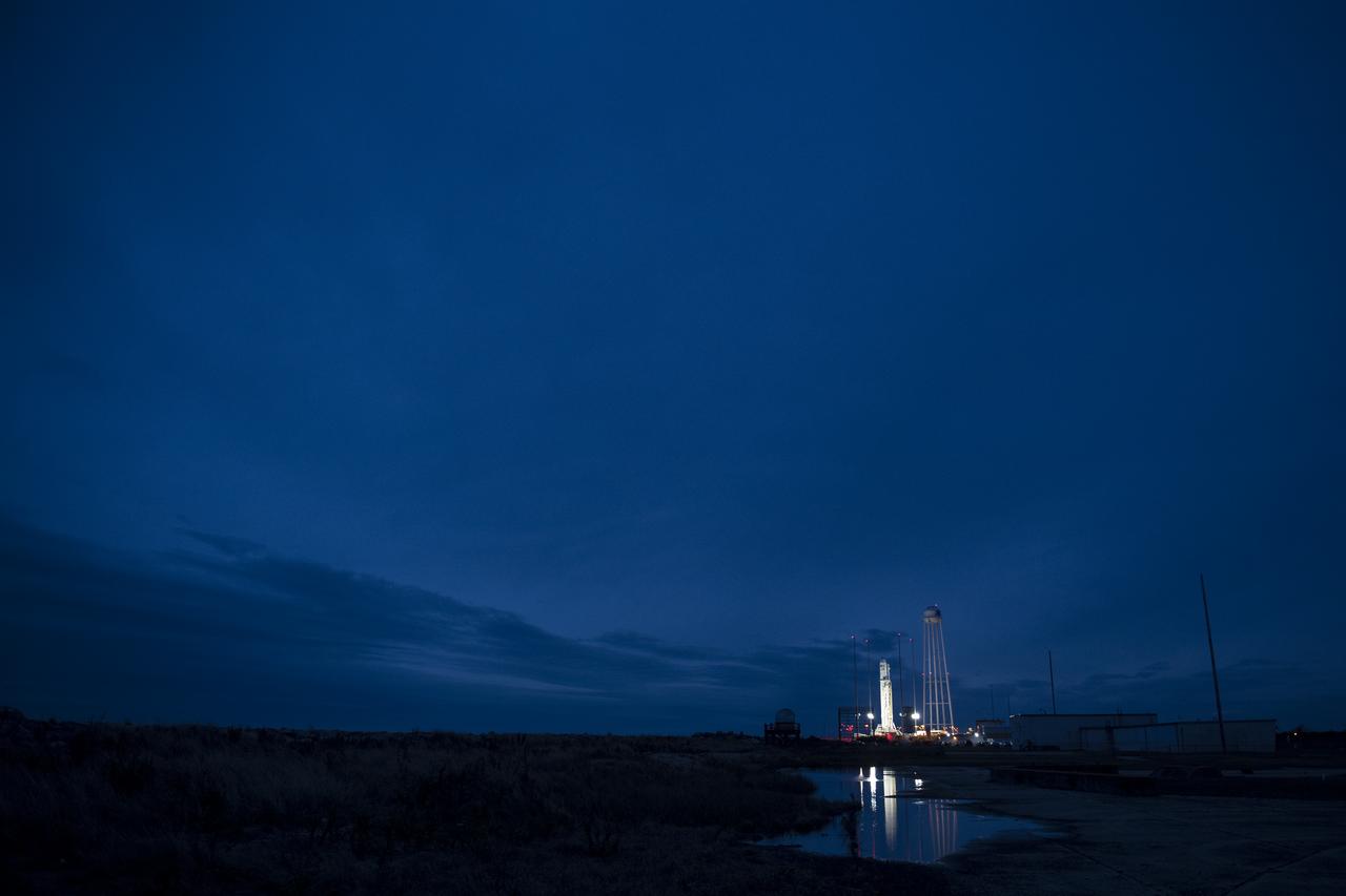 The Northrop Grumman Antares rocket, with Cygnus spacecraft onboard, is seen on Pad-0A after sunset, Tuesday, Nov. 13, 2018 at NASA's Wallops Flight Facility in Virginia. Northrop Grumman's 10th contracted cargo resupply mission for NASA to the International Space Station will deliver about 7,500 pounds of science and research, crew supplies and vehicle hardware to the orbital laboratory and its crew. Launch is scheduled for Nov. 15 at 4:49 a.m. EST. Photo Credit: (NASA/Joel Kowsky)