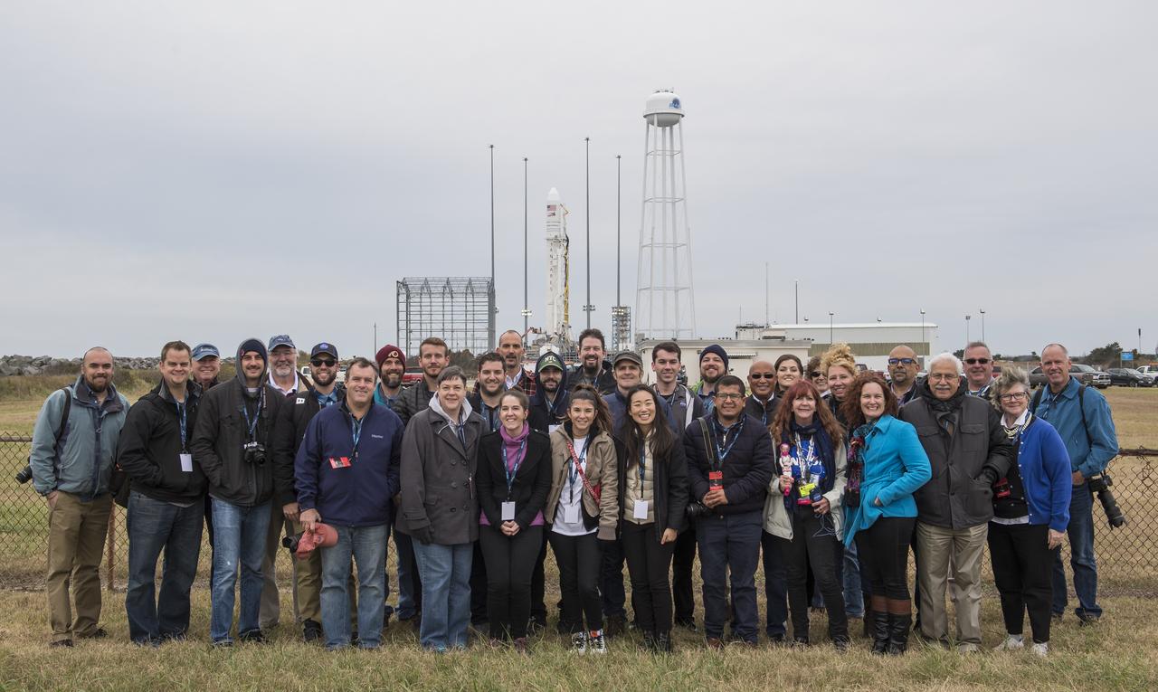 NASA social media attendees pose for a group photograph in front of a Northrop Grumman Antares rocket with Cygnus resupply spacecraft onboard, Wednesday, Nov. 14, 2018 at NASA's Wallops Flight Facility in Virginia. Northrop Grumman's 10th contracted cargo resupply mission for NASA to the International Space Station will deliver about 7,400 pounds of science and research, crew supplies and vehicle hardware to the orbital laboratory and its crew. Launch is currently scheduled for Nov. 16 at 4:23 a.m. EST. Photo Credit: (NASA/Joel Kowsky)