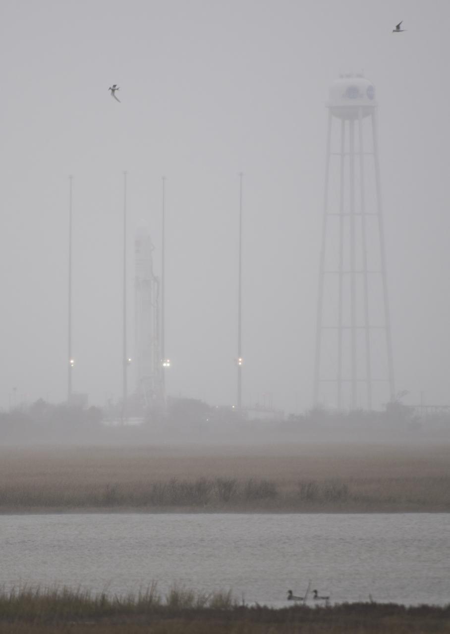 The Northrop Grumman Antares rocket, with Cygnus resupply spacecraft onboard, is seen on Pad-0A as rain and high winds move through the area, Thursday, Nov. 15, 2018 at NASA's Wallops Flight Facility in Virginia. Northrop Grumman's 10th contracted cargo resupply mission for NASA to the International Space Station will deliver about 7,400 pounds of science and research, crew supplies and vehicle hardware to the orbital laboratory and its crew. Launch is currently targeted for Saturday, Nov. 17 at 4:01 a.m. EST. Photo Credit: (NASA/Joel Kowsky)