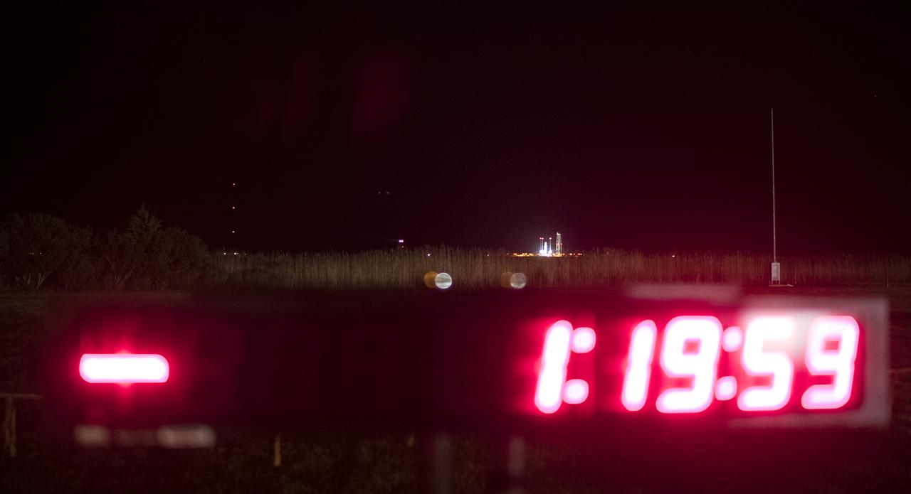 The Northrop Grumman Antares rocket, with Cygnus resupply spacecraft onboard, is seen in the distance on Pad-0A with a viewing site countdown clock in the early hours of Saturday, Nov. 17, 2018 at NASA's Wallops Flight Facility in Virginia. Northrop Grumman's 10th contracted cargo resupply mission for NASA to the International Space Station will deliver about 7,400 pounds of science and research, crew supplies and vehicle hardware to the orbital laboratory and its crew. Photo Credit: (NASA/Joel Kowsky)