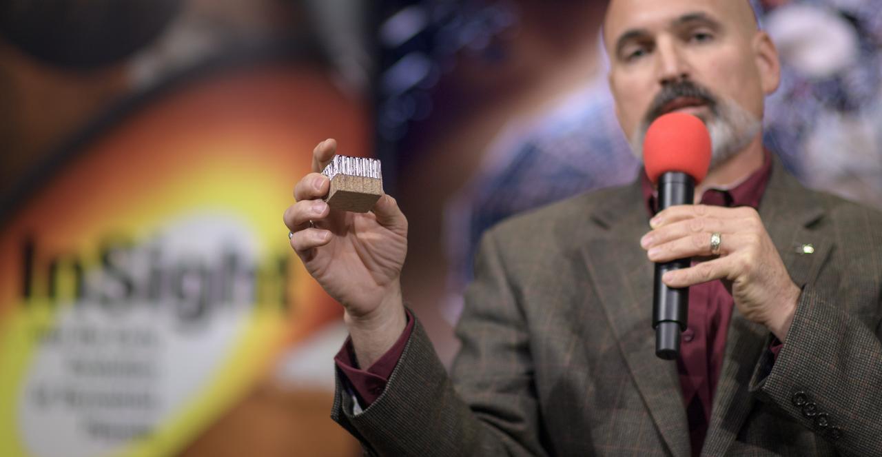 Tim Priser, Quality Director, Lockheed Martin Space talks shows a small piece of the Mars InSight heat shield during a social media briefing, Sunday, Nov. 25, 2018 at NASA's Jet Propulsion Laboratory in Pasadena, California.  InSight, short for Interior Exploration using Seismic Investigations, Geodesy and Heat Transport, is a Mars lander designed to study the "inner space" of Mars: its crust, mantle, and core. InSight is scheduled to touch down on the Red Planet at approximately noon PST (3 p.m. EST) on Nov. 26. Photo Credit: (NASA/Bill Ingalls)