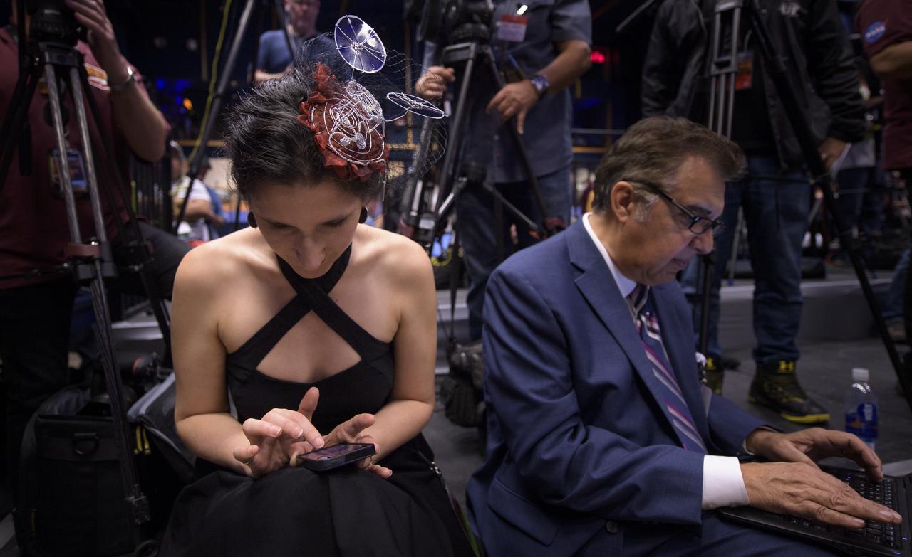 Journalist Mika McKinnon takes notes during a Mars InSight post-landing press conference while wearing a small model of the lander in her hair, Monday, Nov. 26, 2018 at NASA's Jet Propulsion Laboratory in Pasadena, California. InSight, short for Interior Exploration using Seismic Investigations, Geodesy and Heat Transport, is a Mars lander designed to study the "inner space" of Mars: its crust, mantle, and core. Photo Credit: (NASA/Bill Ingalls)