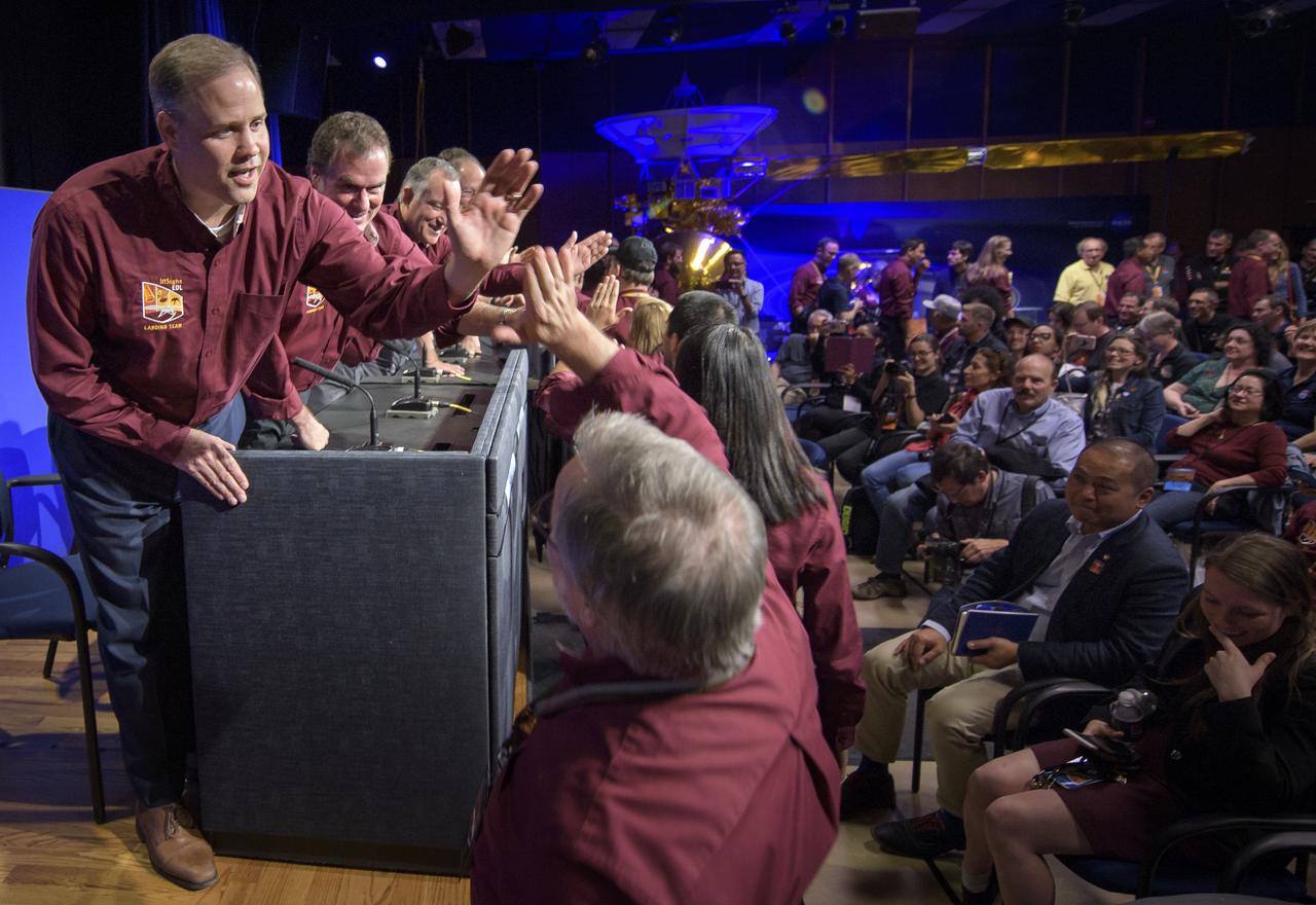 NASA Administrator Jim Bridenstine, left, Mars Cube One, and Mars InSight team members, give each other high fives at the conclusion of a Mars InSight post-landing  press conference, Monday, Nov. 26, 2018 at NASA's Jet Propulsion Laboratory in Pasadena, California. InSight, short for Interior Exploration using Seismic Investigations, Geodesy and Heat Transport, is a Mars lander designed to study the "inner space" of Mars: its crust, mantle, and core. Photo Credit: (NASA/Bill Ingalls)