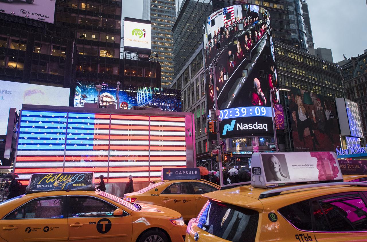 The live NASA TV broadcast from inside the Mission Support Area of NASA's Jet Propulsion Laboratory is seen on the video board of the Nasdaq MarketSite as NASA's InSight lander begins its descent towards the surface of Mars, Monday, Nov. 26, 2018 in Times Square in New York City. The lander sent a signal affirming a completed landing sequence at approximately 3 p.m. EST (noon PST) after touching down on the western side of a flat, smooth expanse of lava called Elysium Planitila. InSight, short for Interior Exploration using Seismic Investigations, Geodesy and Heat Transport, is a Mars lander designed to study the "inner space" of Mars: its crust, mantle, and core. Photo Credit: (NASA/Joel Kowsky)