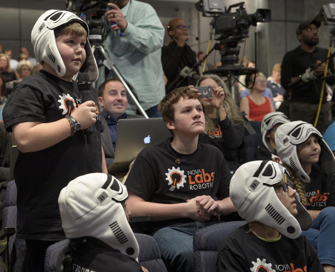 A Nova Labs Robotics "BrainStorm Troopers" team member from Reston, Virginia asks a question during an Commercial Lunar Payload Services (CLPS) announcement, Thursday, Nov. 29, 2018 at NASA Headquarters in Washington. Nine companies will be able to bid on delivering science and technology payloads for NASA, including payload integration and operations, launching from Earth and landing on the surface of the Moon. NASA expects to be one of many customers that will use these commercial landing services. Photo Credit: (NASA/Bill Ingalls)