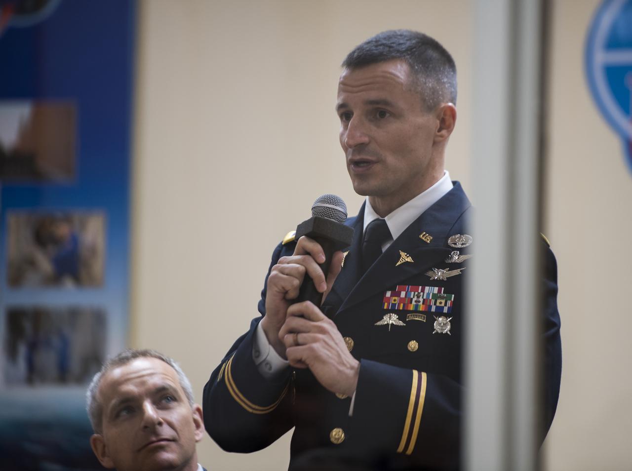 Expedition 58 backup crew member, Flight Engineer Andrew Morgan of NASA, speaks from behind glass, while in quarantine, during the State Commission meeting to approve the Soyuz launch of Expedition 58 to the International Space Station, Sunday, Dec. 2, 2018 at the Cosmonaut Hotel in Baikonur, Kazakhstan. Launch of the Soyuz rocket is scheduled for Dec. 3 and will carry Soyuz Commander Oleg Kononenko of Roscosmos, Flight Engineer Anne McClain of NASA, and Flight Engineer David Saint-Jacques of the Canadian Space Agency (CSA) into orbit to begin their six and a half month mission on the International Space Station. Photo Credit: (NASA/Aubrey Gemignani).