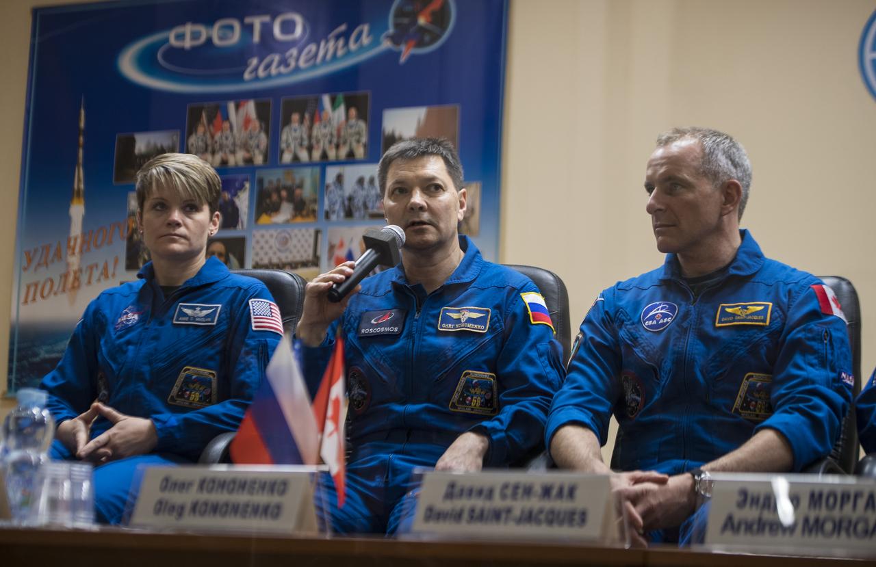 Expedition 58 Soyuz Commander Oleg Kononenko of Roscosmos, center, answers a question during a press conference, Sunday, Dec. 2, 2018 at the Cosmonaut Hotel in Baikonur, Kazakhstan. He is seen with fellow crewmates Flight Engineer Anne McClain of NASA, left, and Flight Engineer David Saint-Jacques of the Canadian Space Agency (CSA), right. Launch of the Soyuz rocket is scheduled for Dec. 3 and will carry Kononenko, McClain, and Saint-Jacques into orbit to begin their six and a half month mission on the International Space Station. Photo Credit: (NASA/Aubrey Gemignani).