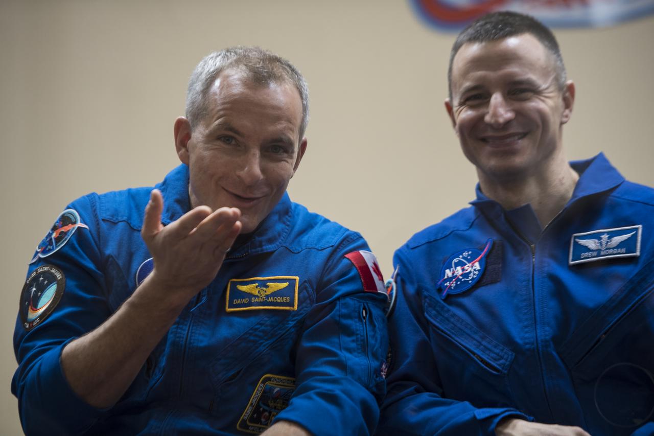 Expedition 58 Flight Engineer David Saint-Jacques of the Canadian Space Agency (CSA), left, blows a kiss to his family during a press conference, Sunday, Dec. 2, 2018 at the Cosmonaut Hotel in Baikonur, Kazakhstan. Launch of the Soyuz rocket is scheduled for Dec. 3 and will carry Expedition 58 prime crew members, Saint-Jacques, Soyuz Commander Oleg Kononenko of Roscosmos, and Flight Engineer Anne McClain of NASA into orbit to begin their six and a half month mission on the International Space Station. Photo Credit: (NASA/Aubrey Gemignani).