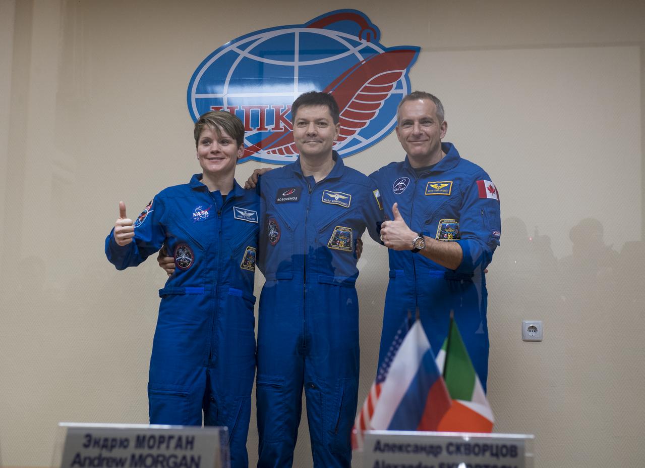 Expedition 58 prime crew members, left to right, Flight Engineer Anne McClain of NASA, Soyuz Commander Oleg Kononenko of Roscosmos, and Flight Engineer David Saint-Jacques of the Canadian Space Agency (CSA) pose for a photo at the conclusion of a press conference, Sunday, Dec. 2, 2018 at the Cosmonaut Hotel in Baikonur, Kazakhstan. Launch of the Soyuz rocket is scheduled for Dec. 3 and will carry Kononenko, McClain, and Saint-Jacques into orbit to begin their six and a half month mission on the International Space Station. Photo Credit: (NASA/Aubrey Gemignani).