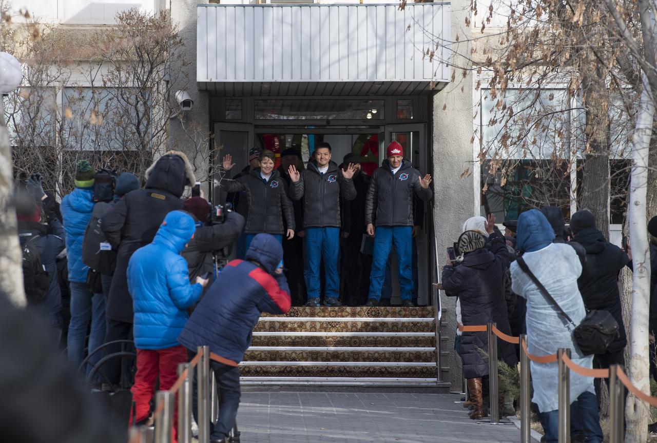 Expedition 58 crew members, Flight Engineer Anne McClain of NASA, left, Soyuz Commander Oleg Kononenko of Roscosmos, center, and Flight Engineer David Saint-Jacques of the Canadian Space Agency (CSA), right, wave farewell to family and friends as they depart the Cosmonaut Hotel to suit-up for their Soyuz launch to the International Space Station on Monday, Dec. 3, 2018 in Baikonur, Kazakhstan. Launch of the Soyuz rocket is scheduled for Dec. 3 and will send Kononenko, McClain, and Saint-Jacques on a six and a half month mission aboard the International Space Station. Photo Credit: (NASA/Aubrey Gemignani)