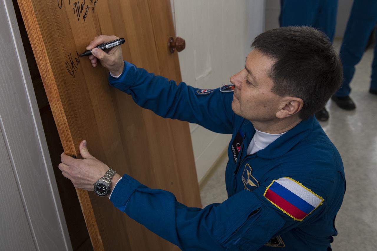 Expedition 58 Soyuz Commander Oleg Kononenko of Roscosmos performs the traditional door signing at the Cosmonaut Hotel prior to departing the hotel for launch in a Soyuz rocket with fellow crewmates, Flight Engineer Anne McClain of NASA and Flight Engineer David Saint-Jacques of the Canadian Space Agency (CSA), Monday, Dec. 3, 2018, in Baikonur, Kazakhstan. Launch of the Soyuz rocket is scheduled for the same day and will carry Kononenko, McClain, and Saint-Jacques into orbit to begin their six and a half month mission on the International Space Station. Photo Credit: (NASA/Aubrey Gemignani)
