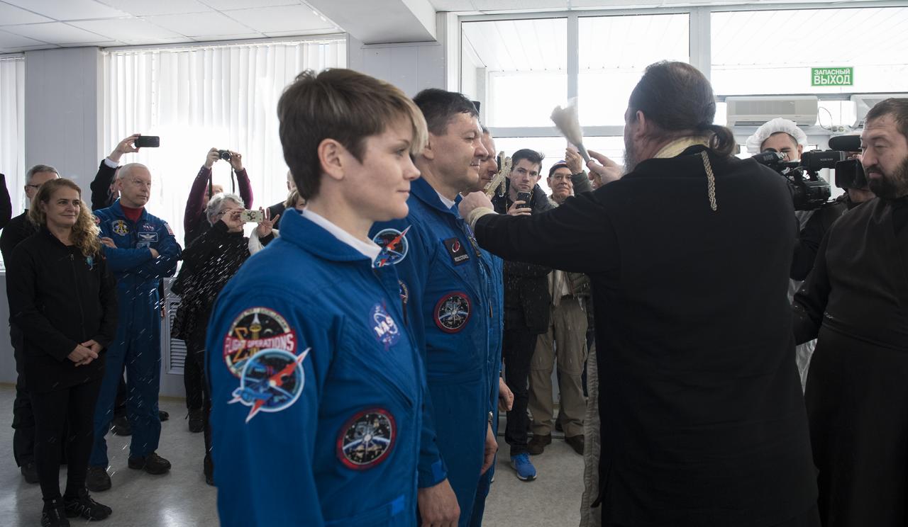 Expedition 58 Flight Engineer David Saint-Jacques of the Canadian Space Agency (CSA), right, receives the traditional blessing from a Russian Orthodox priest at the Cosmonaut Hotel prior to his launch on the Soyuz rocket to the International Space Station (ISS), Monday, Dec. 3, 2018, in Baikonur, Kazakhstan. He and fellow crewmates, Soyuz Commander Oleg Kononenko of Roscosmos, and Flight Engineer Anne McClain of NASA, will spend the next six and a half months living and working aboard the ISS. Photo Credit: (NASA/Aubrey Gemignani)