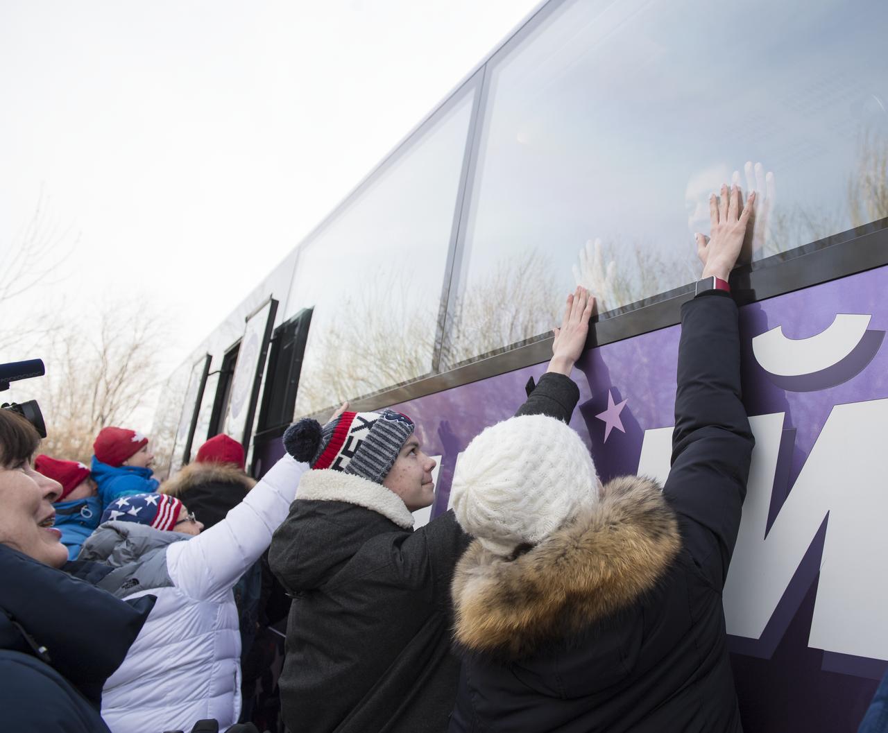 Family of Expedition 58 Soyuz Commander Oleg Kononenko of Roscosmos put their hands up to the window to meet Oleg as the Expedition 58 crew departs the Cosmonaut Hotel to suit-up for their Soyuz launch to the International Space Station on Monday, Dec. 3, 2018 in Baikonur, Kazakhstan. Launch of the Soyuz rocket is scheduled for the same day and will send Kononenko, Flight Engineer Anne McClain of NASA, and Flight Engineer David Saint-Jacques of the Canadian Space Agency (CSA) on a six and a half month mission aboard the International Space Station. Photo Credit: (NASA/Aubrey Gemignani)