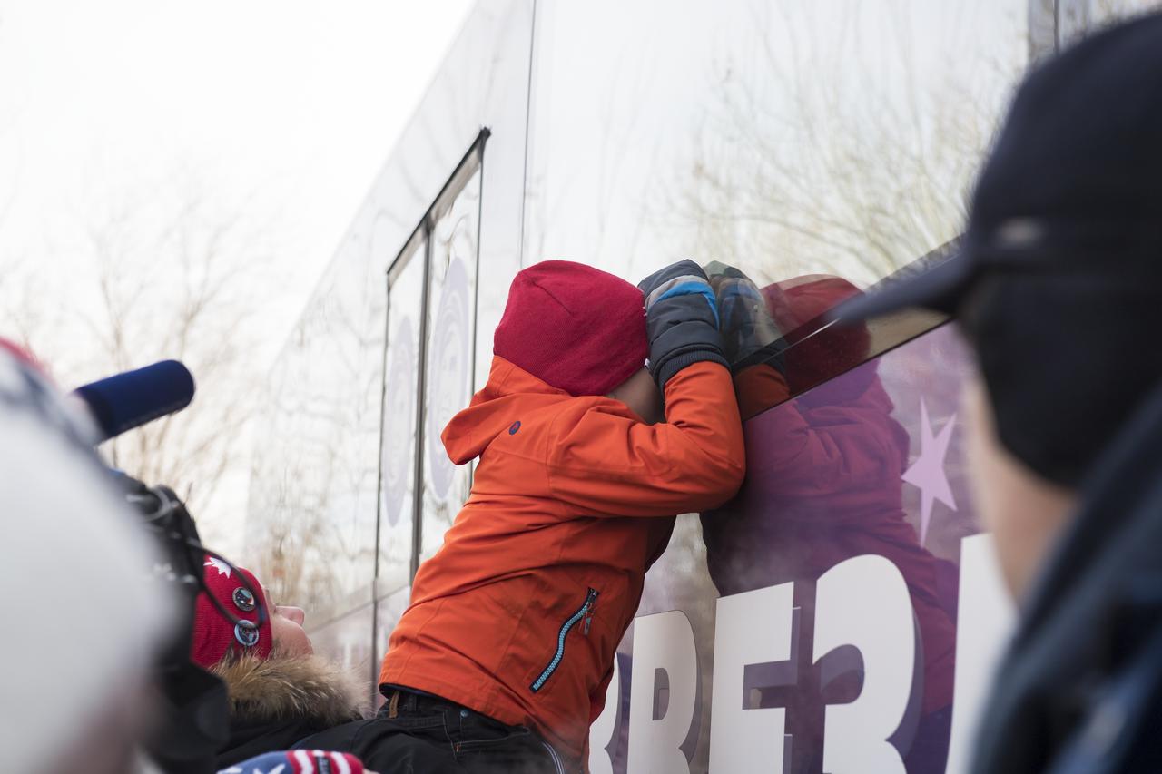Expedition 58 Flight Engineer David Saint-Jacques' son peers through the window of the bus carrying the Expedition 58 crew to building 254 for suit-up for their Soyuz launch to the International Space Station on Monday, Dec. 3, 2018 in Baikonur, Kazakhstan. Launch of the Soyuz rocket is scheduled for the same day and will send Saint-Jacques, Soyuz Commander Oleg Kononenko of Roscosmos, and Flight Engineer Anne McClain of NASA on a six and a half month mission aboard the International Space Station. Photo Credit: (NASA/Aubrey Gemignani)