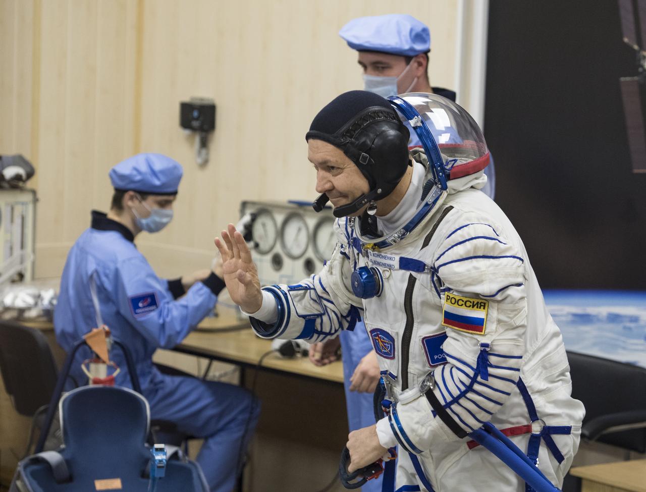 Expedition 58 Soyuz Commander Oleg Kononenko of Roscosmos waves at family and friends after completing his Russian Sokol suit pressure check in preparation for his launch aboard the Soyuz MS-11 spacecraft on Monday, Dec. 3, 2018, at the Baikonur Cosmodrome in Kazakhstan. Launch of the Soyuz rocket is scheduled for the same day and will carry Kononenko, Flight Engineer Anne McClain of NASA, and Flight Engineer David Saint-Jacques of the Canadian Space Agency (CSA) into orbit to begin their six and a half month mission on the International Space Station. Photo Credit: (NASA/Aubrey Gemignani)