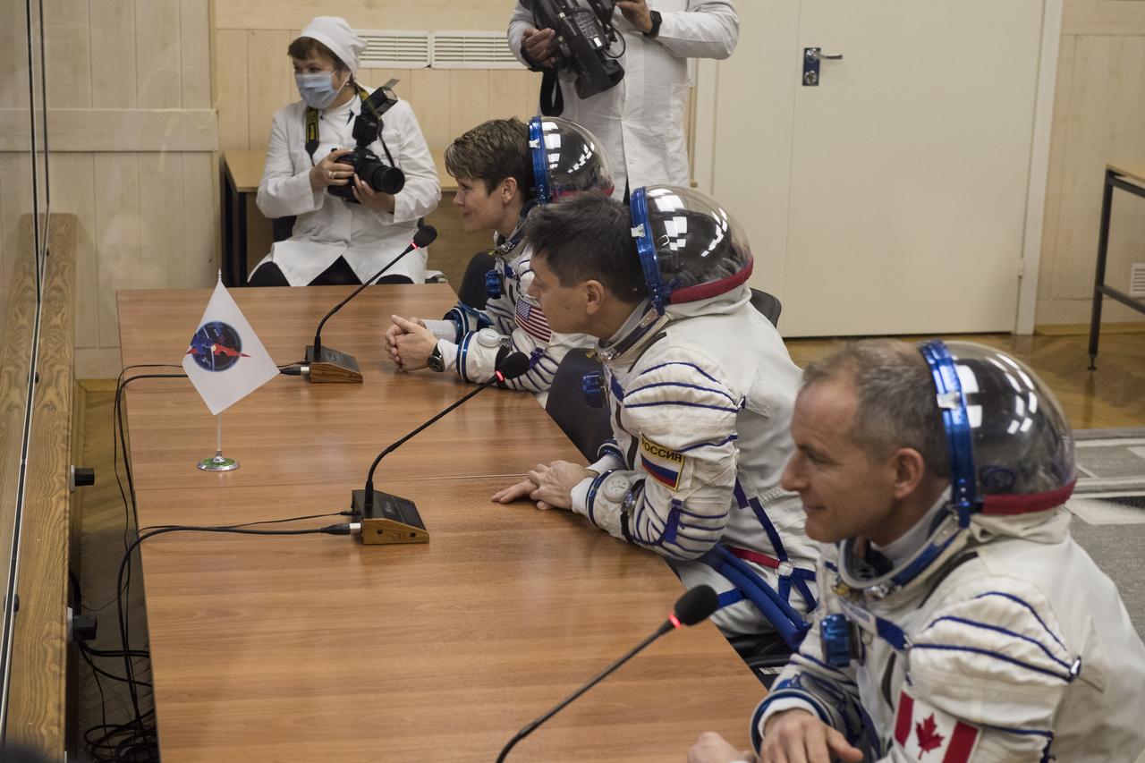 Expedition 58 crew, from top to bottom, Flight Engineer Anne McClain of NASA, Soyuz Commander Oleg Kononenko of Roscosmos, and Flight Engineer David Saint-Jacques of the Canadian Space Agency (CSA) speak to family and friends after having their Russian Sokol suits pressure checked in preparation for their launch aboard the Soyuz MS-11 spacecraft on Monday, Dec. 3, 2018, at the Baikonur Cosmodrome in Kazakhstan. Launch of the Soyuz rocket is scheduled for the same day and will carry Kononenko, Saint-Jacques, and McClain into orbit to begin their six and a half month mission on the International Space Station. Photo Credit: (NASA/Aubrey Gemignani)