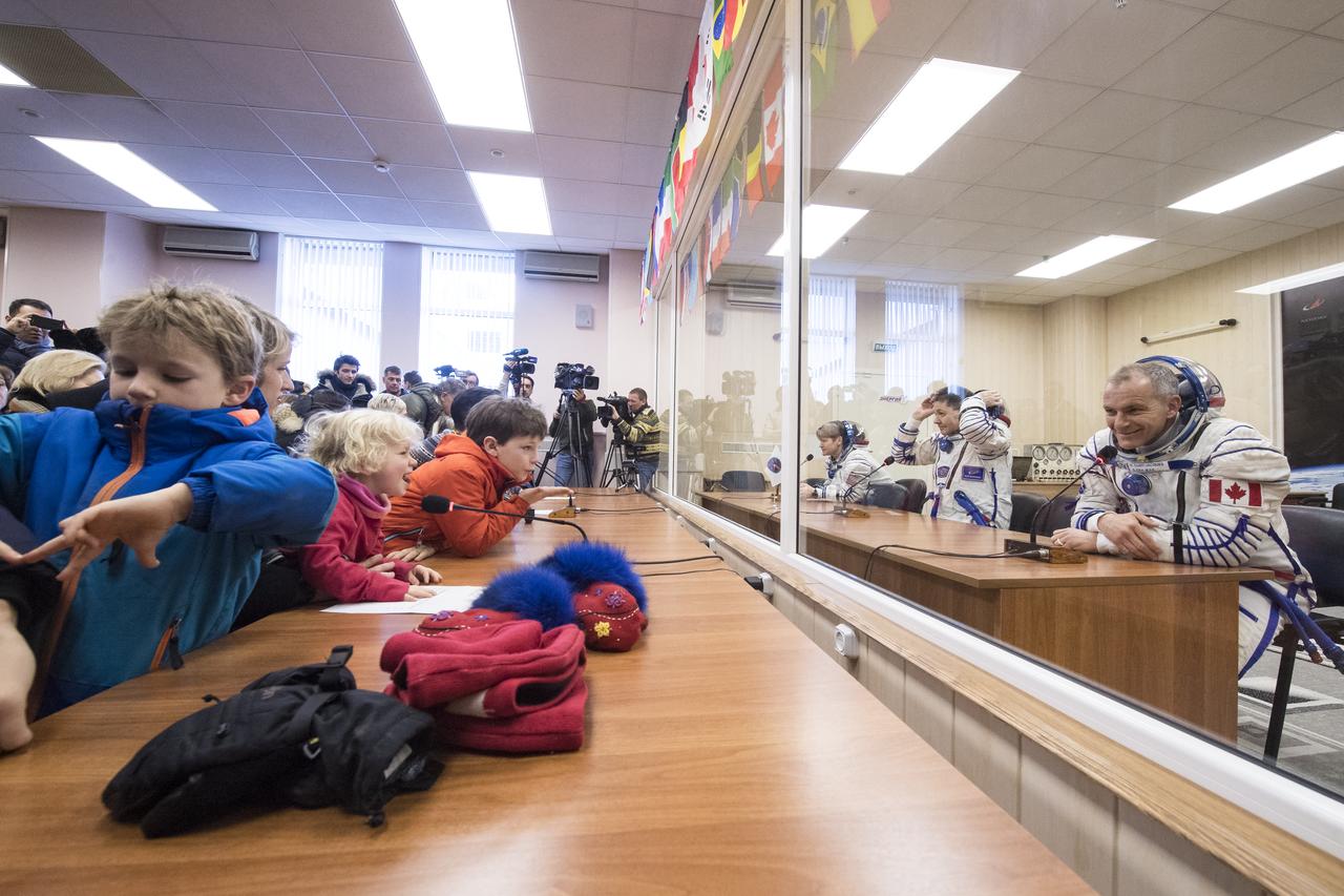 Expedition 58 crew, from top to bottom, Flight Engineer Anne McClain of NASA, Soyuz Commander Oleg Kononenko of Roscosmos, and Flight Engineer David Saint-Jacques of the Canadian Space Agency (CSA) speak to family and friends after having their Russian Sokol suits pressure checked in preparation for their launch aboard the Soyuz MS-11 spacecraft on Monday, Dec. 3, 2018, at the Baikonur Cosmodrome in Kazakhstan. Launch of the Soyuz rocket is scheduled for the same day and will carry Kononenko, Saint-Jacques, and McClain into orbit to begin their six and a half month mission on the International Space Station. Photo Credit: (NASA/Aubrey Gemignani)