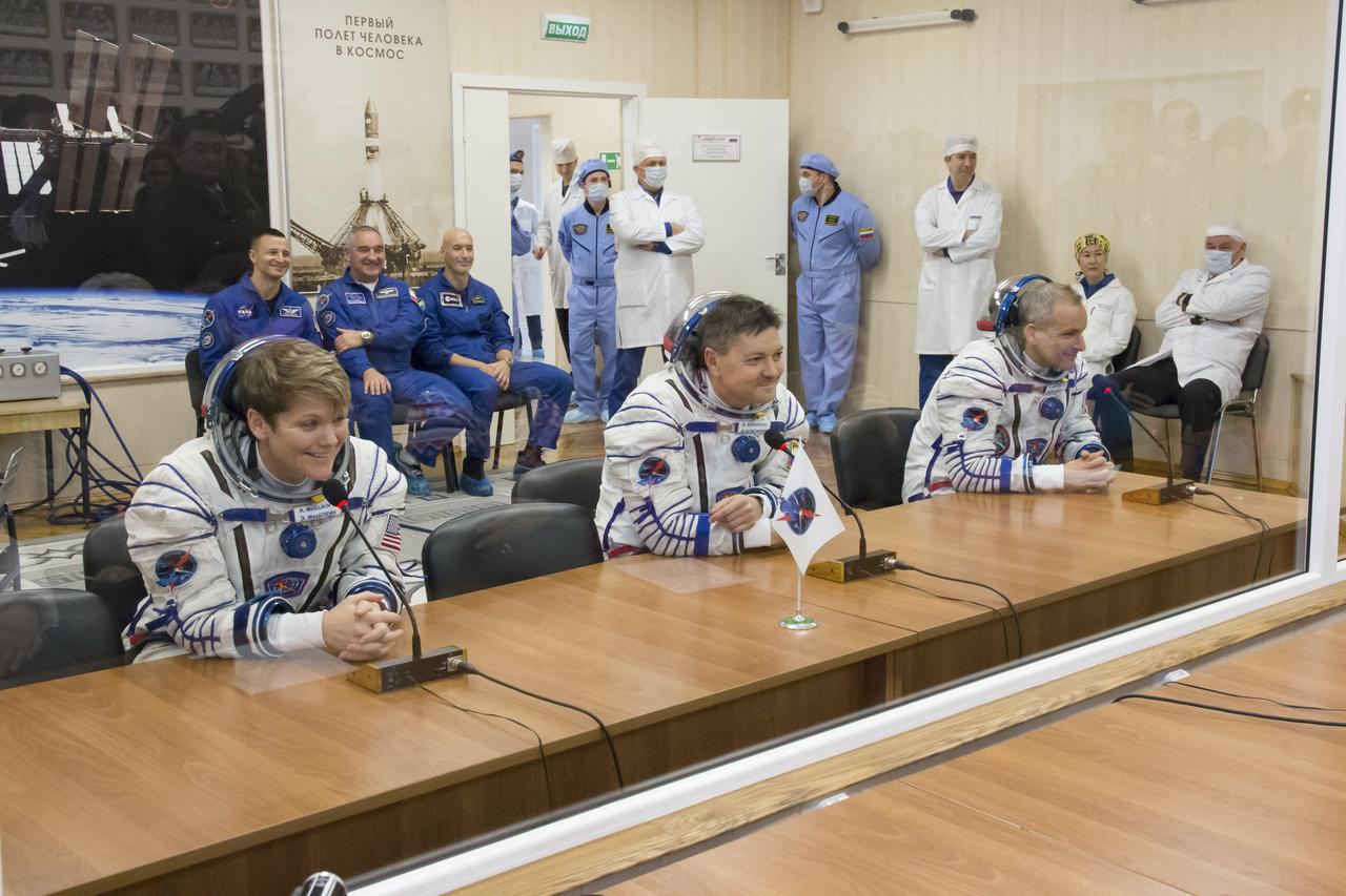 Expedition 58 crew, from left to right, Flight Engineer Anne McClain of NASA, Soyuz Commander Oleg Kononenko of Roscosmos, and Flight Engineer David Saint-Jacques of the Canadian Space Agency (CSA) speak to family and friends after having their Russian Sokol suits pressure checked in preparation for their launch aboard the Soyuz MS-11 spacecraft on Monday, Dec. 3, 2018, at the Baikonur Cosmodrome in Kazakhstan. Launch of the Soyuz rocket is scheduled for the same day and will carry Kononenko, Saint-Jacques, and McClain into orbit to begin their six and a half month mission on the International Space Station. Photo Credit: (NASA/Victor Zelentsov)