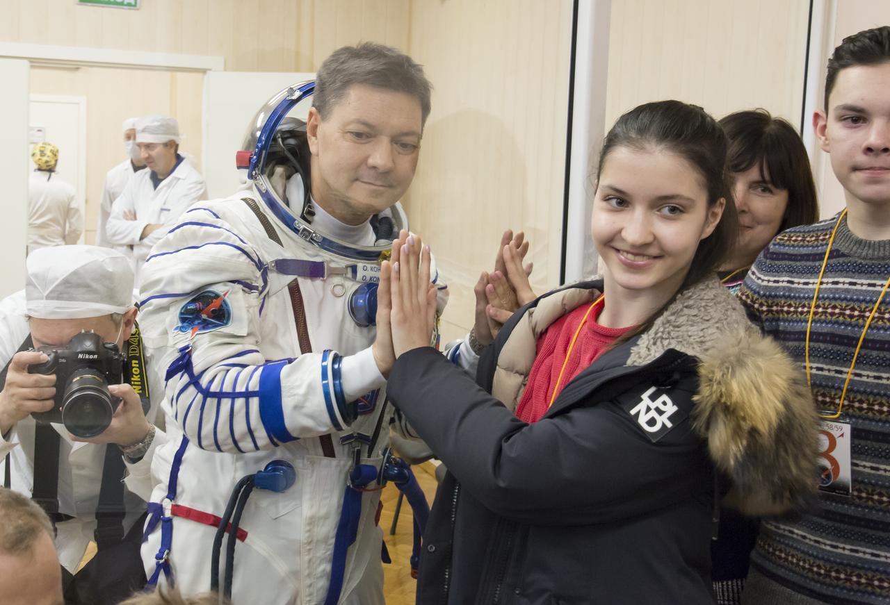 Expedition 58 Soyuz Commander Oleg Kononenko of Roscosmos puts his hands up to the glass, to meet his daughters, while in quarantine, after having his Russian Sokol suit pressure checked in preparation for his launch aboard the Soyuz MS-11 spacecraft on Monday, Dec. 3, 2018, at the Baikonur Cosmodrome in Kazakhstan. Launch of the Soyuz rocket is scheduled for the same day and will carry Kononenko, Flight Engineer Anne McClain of NASA, and Flight Engineer David Saint-Jacques of the Canadian Space Agency (CSA) into orbit to begin their six and a half month mission on the International Space Station. Photo Credit: (NASA/Victor Zelentsov)