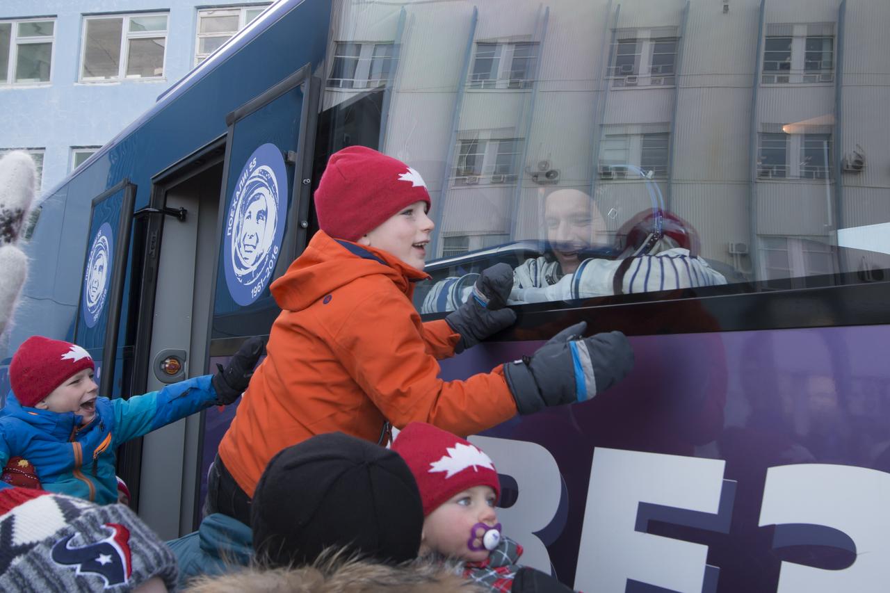Expedition 58 Flight Engineer David Saint-Jacques of the Canadian Space Agency (CSA) says farewell to his family through the window of the bus before heading to the launch pad to board the Soyuz MS-11 spacecraft on Monday, Dec. 3, 2018, at the Baikonur Cosmodrome in Kazakhstan. Launch of the Soyuz rocket is scheduled for the same day and will carry Saint-Jacques, Soyuz Commander Oleg Kononenko of Roscosmos, and Flight Engineer Anne McClain of NASA into orbit to begin their six and a half month mission on the International Space Station. Photo Credit: (NASA/Victor Zelentsov)