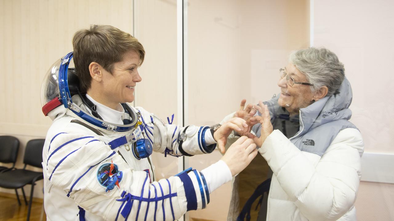 Expedition 58 Flight Engineer Anne McClain of NASA, who is in quarantine, puts her hand up to the glass to meet her mother at the conclusion of a press conference, Sunday, Dec. 2, 2018 at the Cosmonaut Hotel in Baikonur, Kazakhstan. Launch of the Soyuz rocket is scheduled for Dec. 3 that will carry McClain, Soyuz Commander Oleg Kononenko of Roscosmos, and Flight Engineer David Saint-Jacques of the Canadian Space Agency (CSA) into orbit to begin their six and a half month mission on the International Space Station. Photo Credit: (NASA/Aubrey Gemignani). Expedition 58 Flight Engineer Anne McClain of NASA, who is in quarantine, puts her hand up to the glass to meet her mother after having her Russian Sokol suit pressure checked in preparation for her launch aboard the Soyuz MS-11 spacecraft on Monday, Dec. 3, 2018, at the Baikonur Cosmodrome in Kazakhstan. Launch of the Soyuz rocket is scheduled for the same day and will carry McClain, Soyuz Commander Oleg Kononenko of Roscosmos, and Flight Engineer David Saint-Jacques of the Canadian Space Agency (CSA) into orbit to begin their six and a half month mission on the International Space Station. Photo Credit: ((GCTC/NASA/Andrey Shelepin))