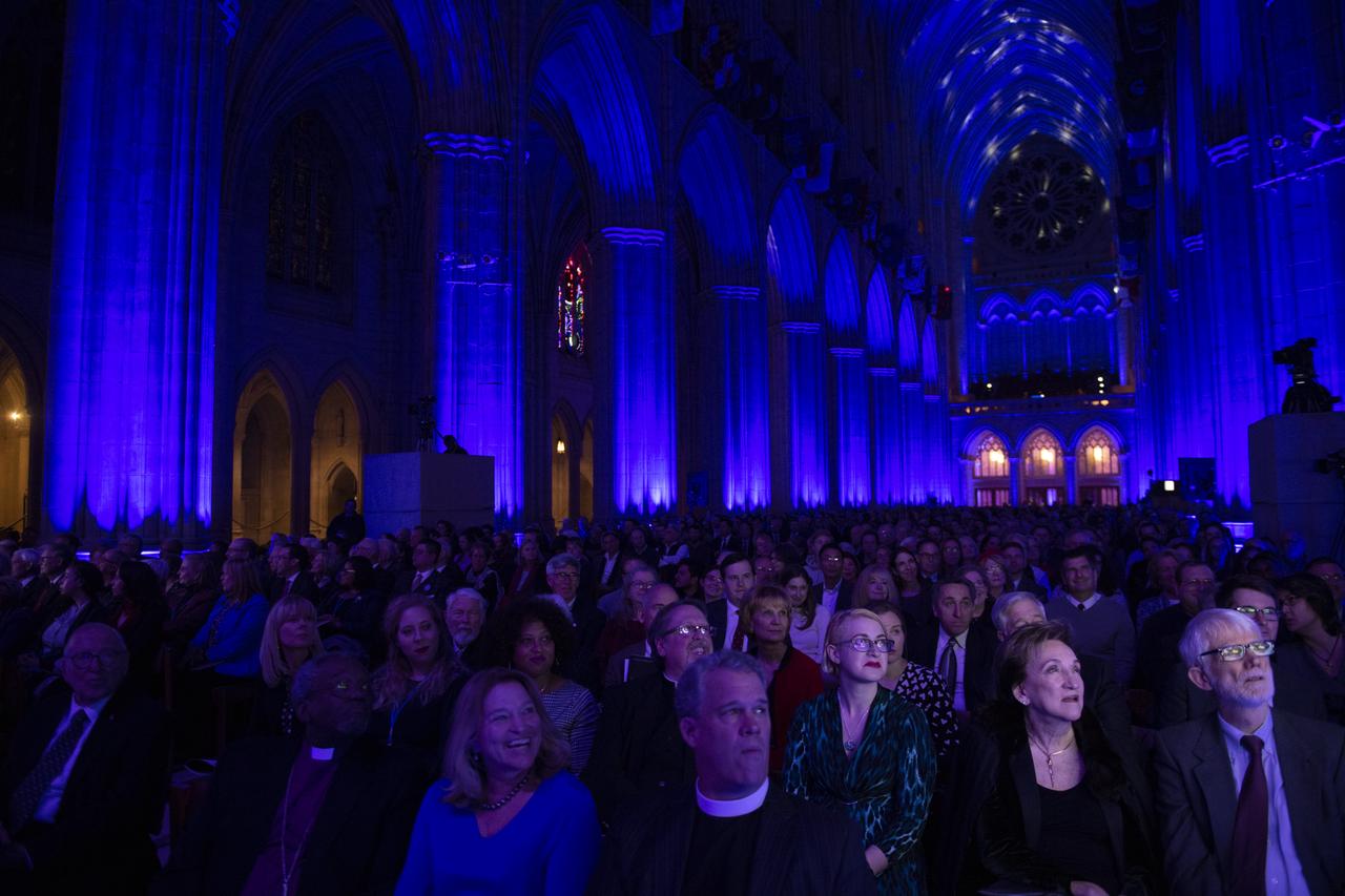 The audience is seen while a video about the Apollo 8 mission is shown on monitors during the Smithsonian National Air and Space Museum's Spirit of Apollo event commemorating the 50th anniversary of Apollo 8, Tuesday, Dec. 11, 2018 at the Washington National Cathedral in Washington, DC. Apollo 8 was humanity's first journey to another world, taking astronauts Frank Borman, Jim Lovell, and William Anders to the Moon and back in December of 1968. Photo Credit: (NASA/Joel Kowsky)