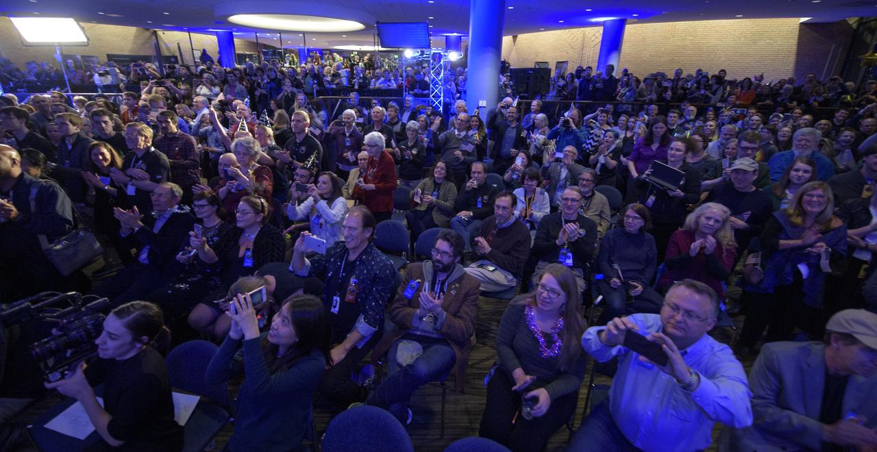 Guests watch as Brian May, lead guitarist of the rock band Queen and astrophysicist shows a video with a new song he wrote for the New Horizons mission, Tuesday, Jan. 1, 2019 at Johns Hopkins University Applied Physics Laboratory (APL) in Laurel, Maryland. Photo Credit: (NASA/Bill Ingalls)