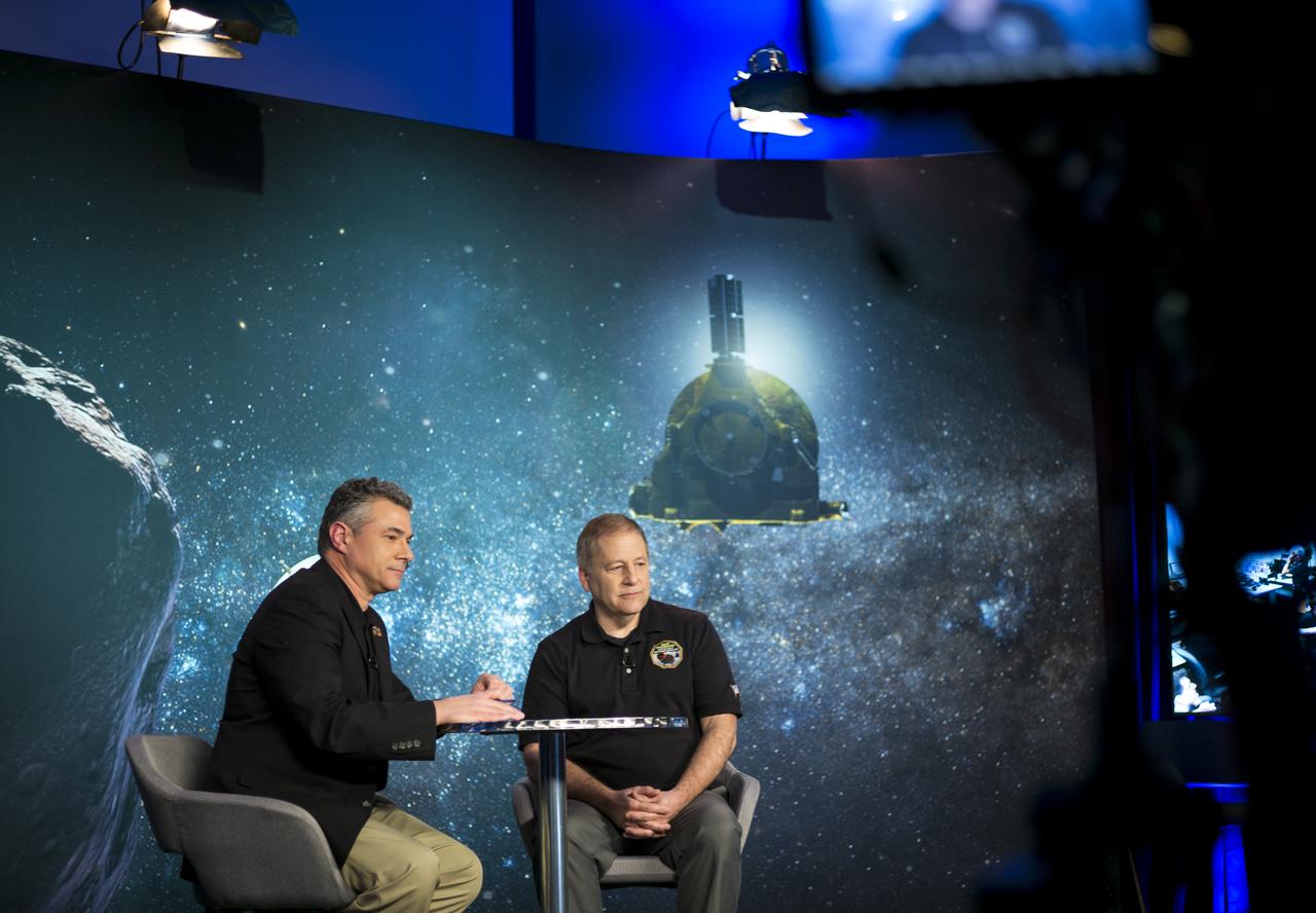 Mike Buckley, senior public information officer at the Johns Hopkins University Applied Physics Laboratory, left, and New Horizons encounter mission manager Mark Holdridge of the Johns Hopkins University Applied Physics Laboratory, right, watch a live feed of the Mission Operations Center (MOC) along with guests and New Horizons team members as they wait to receive confirmation from the spacecraft that it has completed the flyby of Ultima Thule, Tuesday, Jan. 1, 2019 at Johns Hopkins University Applied Physics Laboratory (APL) in Laurel, Maryland. Photo Credit: (NASA/Joel Kowsky)