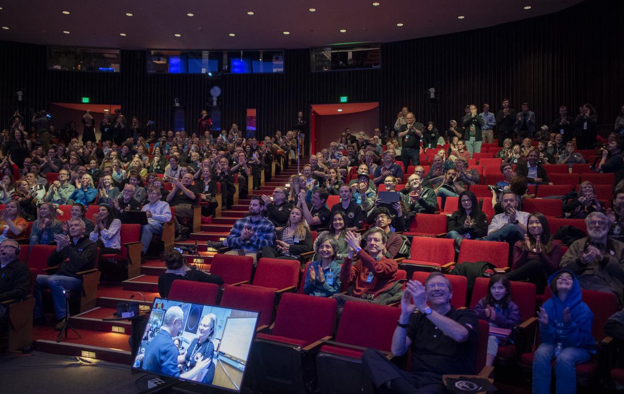 New Horizons principal investigator Alan Stern of the Southwest Research Institute (SwRI), Boulder, CO and  New Horizons Mission Operations Manager Alice Bowman of the Johns Hopkins University Applied Physics Laboratory are seen on a television screen as New Horizons team members and guests cheer as the team receives confirmation from the spacecraft that it has completed the flyby of Ultima Thule, Tuesday, Jan. 1, 2019 at Johns Hopkins University Applied Physics Laboratory (APL) in Laurel, Maryland. Photo Credit: (NASA/Joel Kowsky)