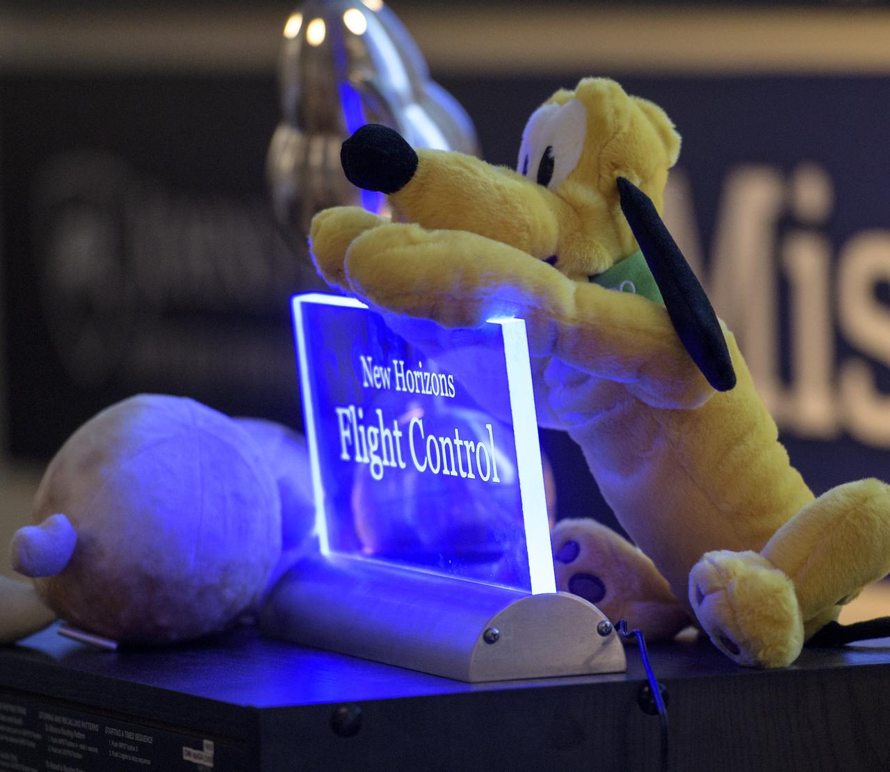 A sign marking the seat location of the New Horizons Flight Controller is seen as team members wait for a signal from the spacecraft that it is healthy and collected data during the flyby of Ultima Thule, Tuesday, Jan. 1, 2019 at the Mission Operations Center of the Johns Hopkins University Applied Physics Laboratory (APL) in Laurel, Maryland. Photo Credit: (NASA/Bill Ingalls)