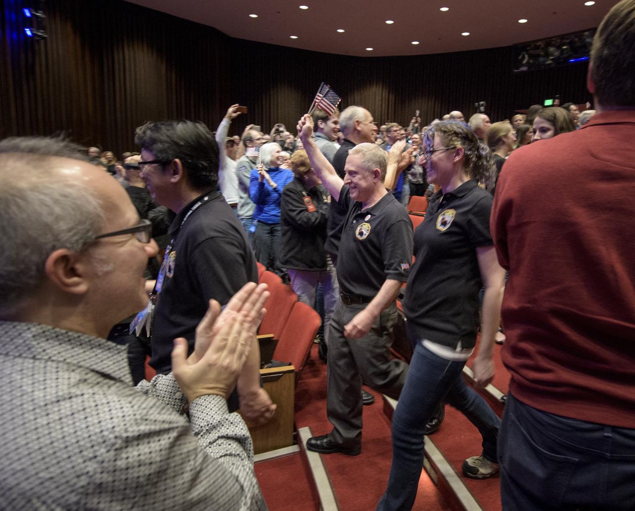 New Horizons principal investigator Alan Stern of the Southwest Research Institute (SwRI), Boulder, CO, along with other mission team members, waves American flags as he enters the main auditorium for a press conference, Tuesday, Jan. 1, 2019 at Johns Hopkins University Applied Physics Laboratory (APL) in Laurel, Maryland. The New Horizons team received signals from the spacecraft that it is healthy and it collected data during the fly of Ultima Thule. Photo Credit: (NASA/Bill Ingalls)