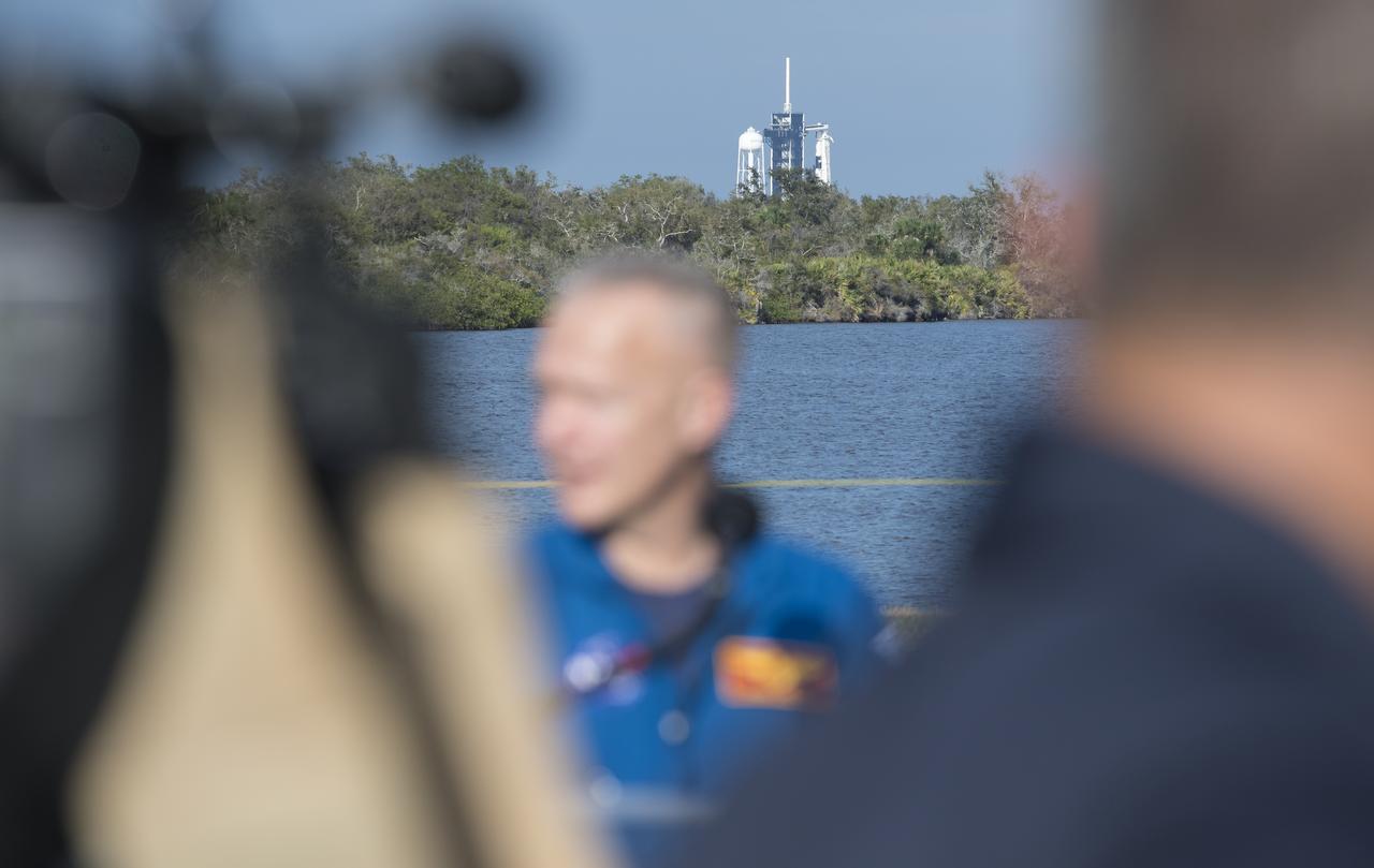 A SpaceX Falcon 9 rocket with the company's Crew Dragon spacecraft onboard is seen in the distance on the launch pad at Launch Complex 39A during a press conference ahead of the SpaceX Demo-1 mission, Friday, March 1, 2019 at the Kennedy Space Center in Florida. The Demo-1 mission will be the first launch of a commercially built and operated American spacecraft and space system designed for humans as part of NASA's Commercial Crew Program. The mission, currently targeted for a 2:49am launch on March 2, will serve as an end-to-end test of the system's capabilities. Photo Credit: (NASA/Joel Kowsky)
