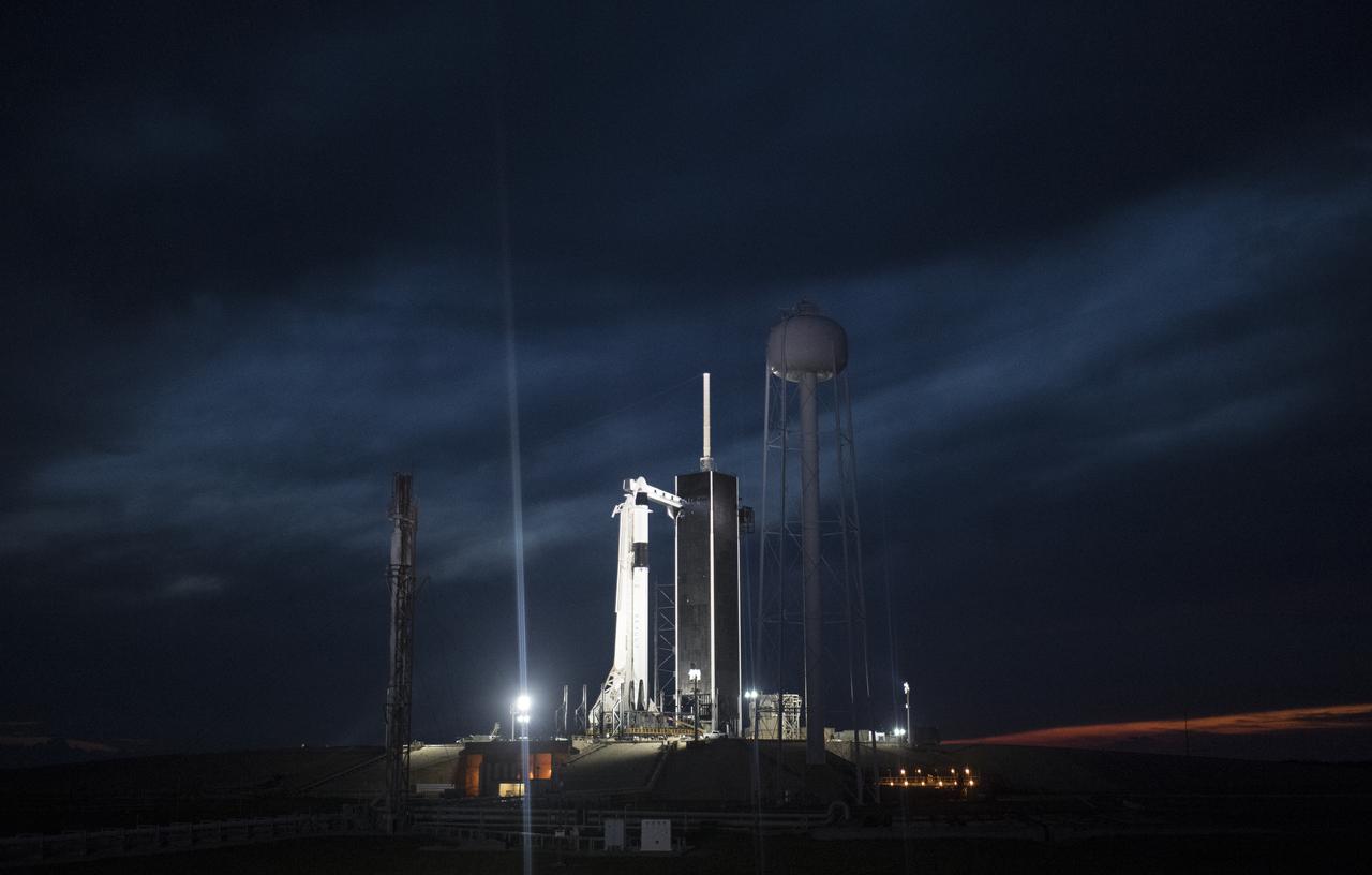 A SpaceX Falcon 9 rocket with the company's Crew Dragon spacecraft onboard is seen illuminated on the launch pad by spotlights at Launch Complex 39A as preparations continue for the Demo-1 mission, Friday, March 1, 2019 at the Kennedy Space Center in Florida. The Demo-1 mission will be the first launch of a commercially built and operated American spacecraft and space system designed for humans as part of NASA's Commercial Crew Program. The mission, currently targeted for a 2:49am launch on March 2, will serve as an end-to-end test of the system's capabilities. Photo Credit: (NASA/Joel Kowsky)