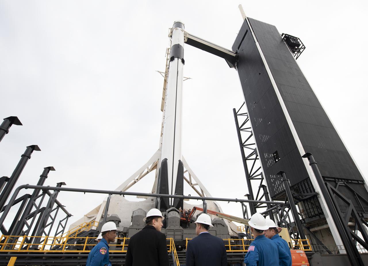 SpaceX CEO and Chief Designer Elon Musk, second from left, NASA Administrator Jim Bridenstine, third form right, and NASA astronauts Mike Hopkins, Victor Glover, Doug Hurley and Bob Behnken are seen with the SpaceX Falcon 9 rocket with the company's Crew Dragon spacecraft onboard during a tour of Launch Complex 39A before the early Saturday morning launch of the Demo-1 mission, Friday, March 1, 2019 at the Kennedy Space Center in Florida. The Demo-1 mission launched at 2:49am ET on Saturday, March 2 and was the first launch of a commercially built and operated American spacecraft and space system designed for humans as part of NASA's Commercial Crew Program. The mission will serve as an end-to-end test of the system's capabilities. Hurley and Behnken are assigned to fly onboard Crew Dragon for the Demo-2 mission and Glover and Hopkins have been assigned to fly to the International Space Station on Crew Dragon's first operational mission. Photo Credit: (NASA/Joel Kowsky)