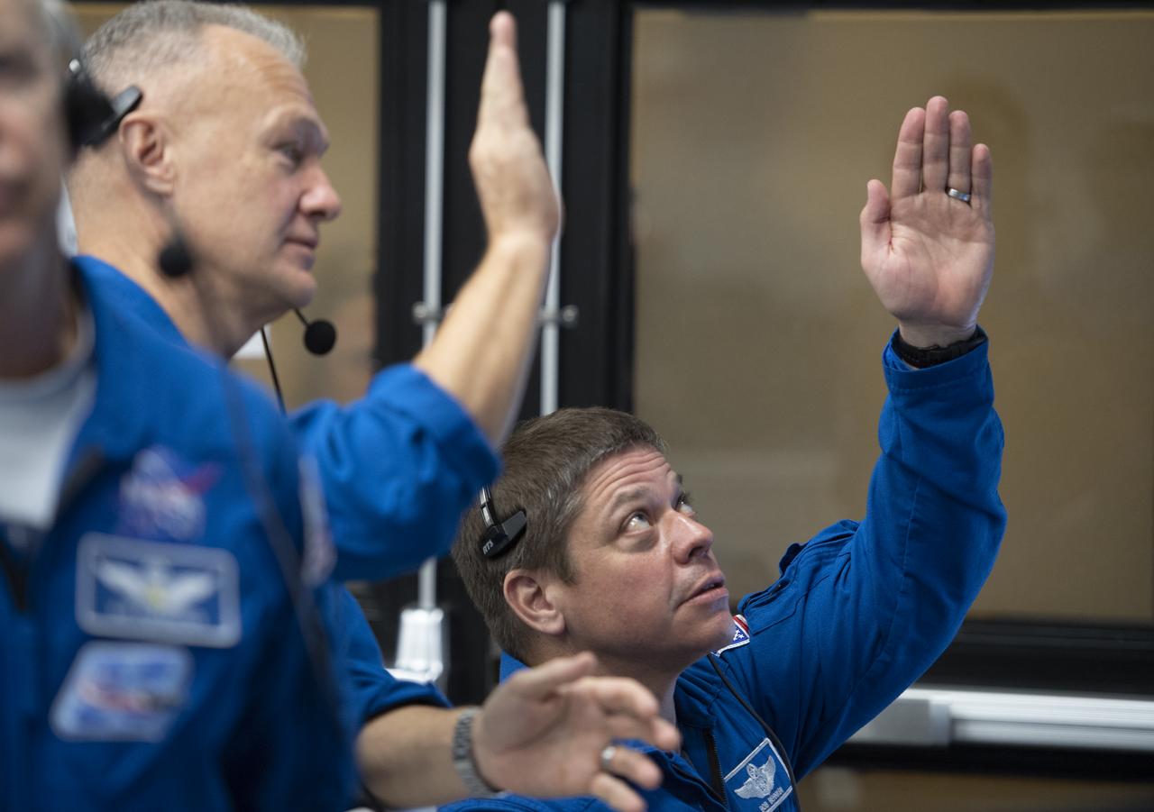 NASA astronauts Doug Hurley, left, and Bob Behnken, right, who are assigned to fly on the crewed Demo-2 mission, watch the launch of a SpaceX Falcon 9 rocket carrying the company's Crew Dragon spacecraft on the Demo-1 mission from firing room four of the Launch Control Center, Saturday, March 2, 2019 at the Kennedy Space Center in Florida. The Demo-1 mission is the first launch of a commercially built and operated American spacecraft and space system designed for humans as part of NASA's Commercial Crew Program. The mission will serve as an end-to-end test of the system's capabilities. Photo Credit: (NASA/Joel Kowsky)