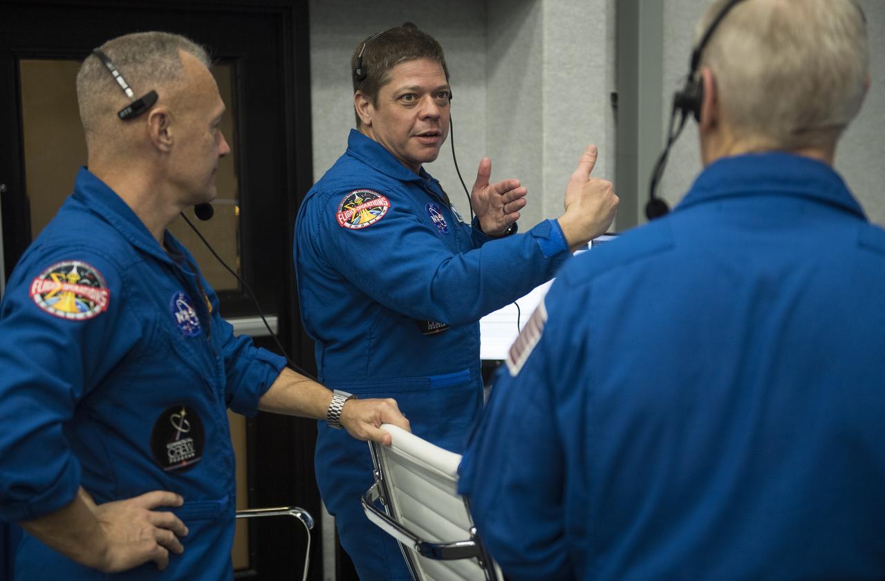 NASA astronauts Doug Hurley, left, and Bob Behnken, right, who are assigned to fly on the crewed Demo-2 mission, watch the launch of a SpaceX Falcon 9 rocket carrying the company's Crew Dragon spacecraft on the Demo-1 mission from firing room four of the Launch Control Center, Saturday, March 2, 2019 at the Kennedy Space Center in Florida. The Demo-1 mission is the first launch of a commercially built and operated American spacecraft and space system designed for humans as part of NASA's Commercial Crew Program. The mission will serve as an end-to-end test of the system's capabilities. Photo Credit: (NASA/Joel Kowsky)