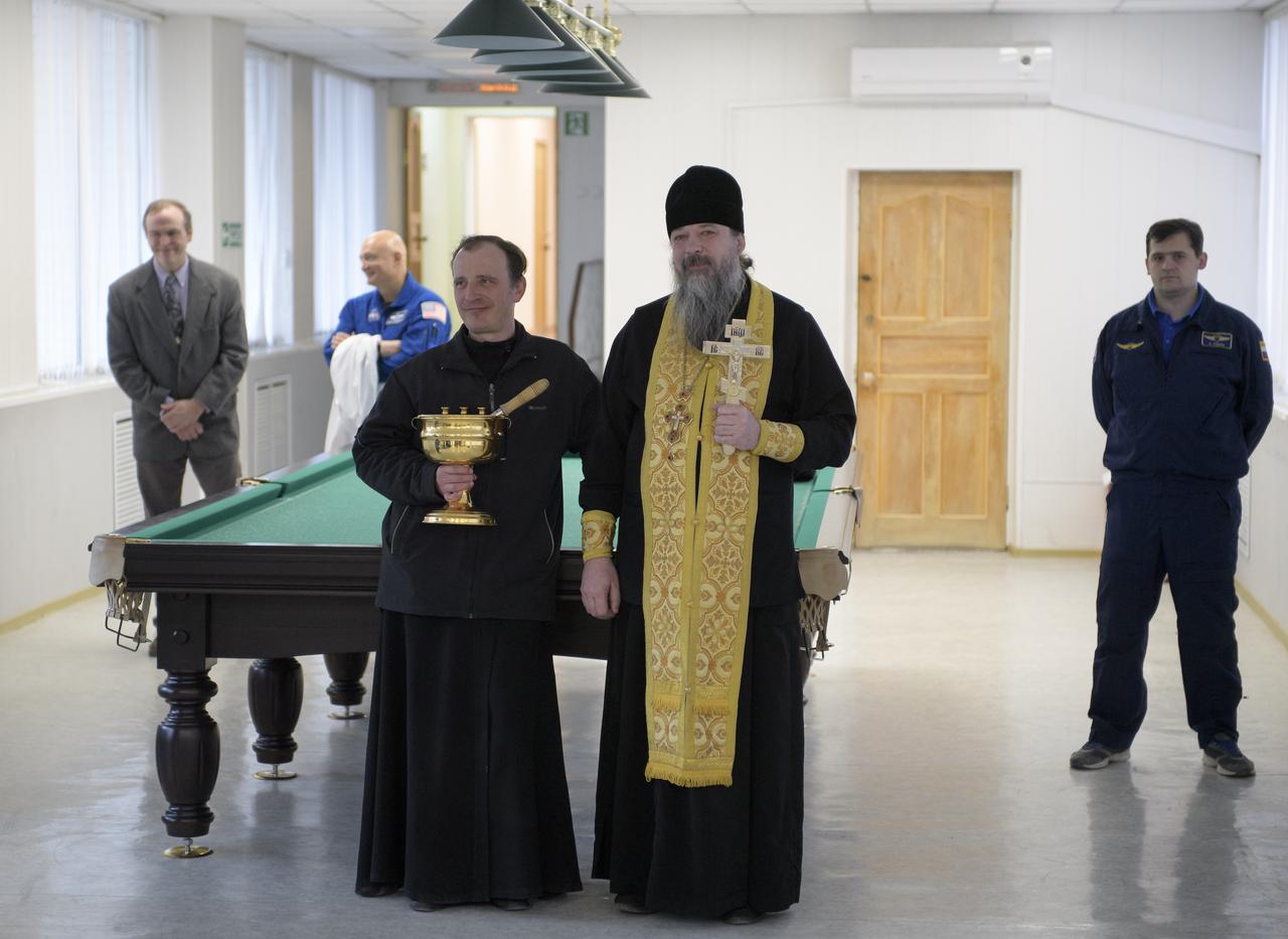 Russian Orthodox Priest Father Sergei waits to bless the Expedition 59 crew in the Cosmonaut Hotel, Thursday, March 14, 2019 in Baikonur, Kazakhstan. Hague, Koch, and Ovchinin will launch March 14, U.S. time, on the Soyuz MS-12 spacecraft from the Baikonur Cosmodrome for a six-and-a-half month mission on the International Space Station. Photo Credit: (NASA/Bill Ingalls)